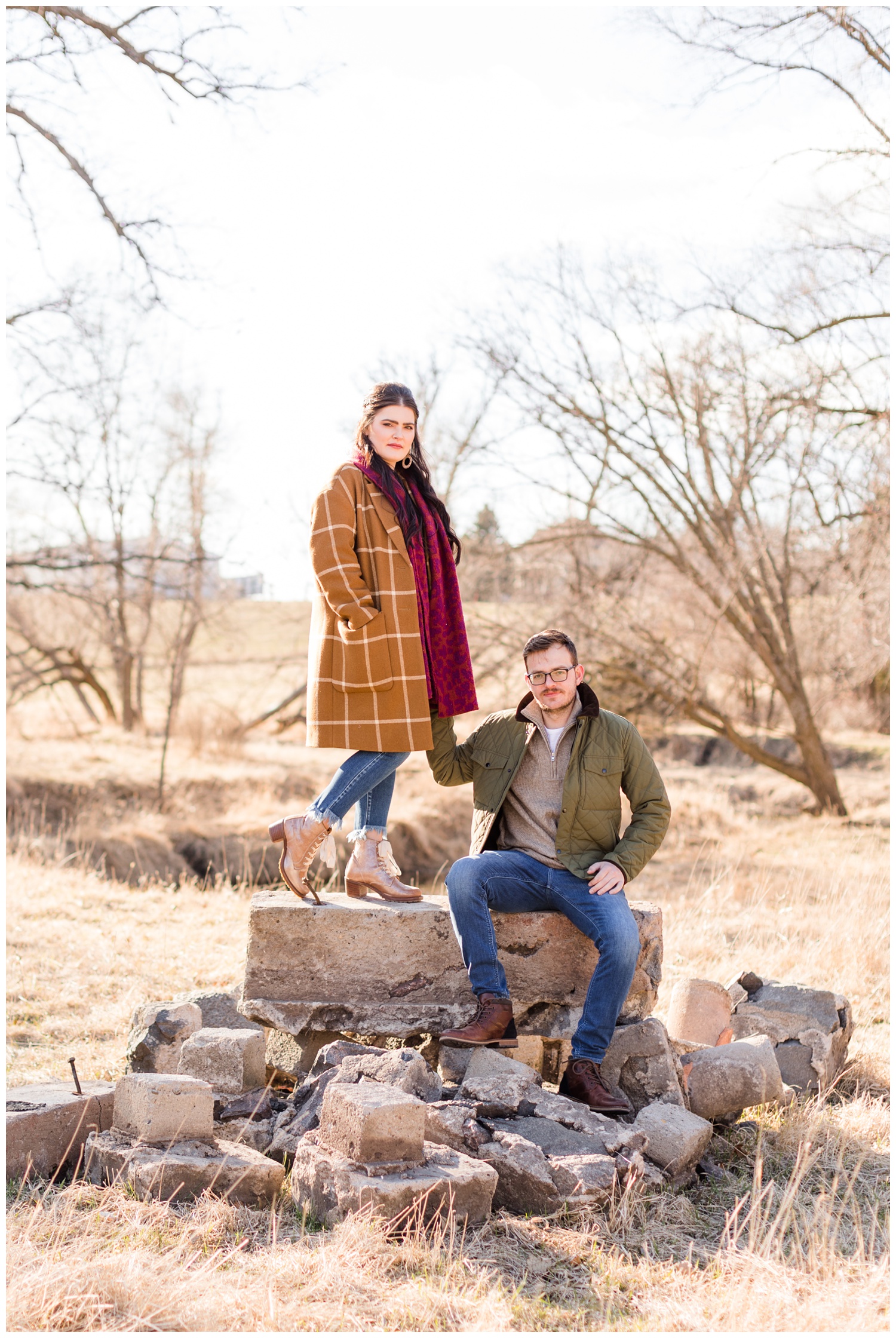 Rachel and Mitch stand on a stone pile while holding hands | CB Studio