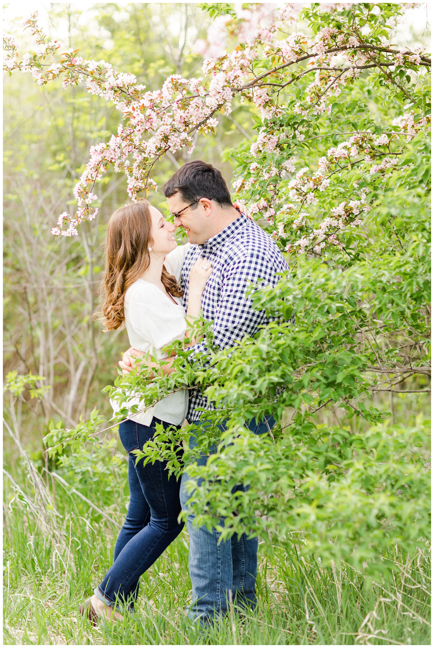 Joe and Leslie embrace underneath a spring blossom tree | CB Studio
