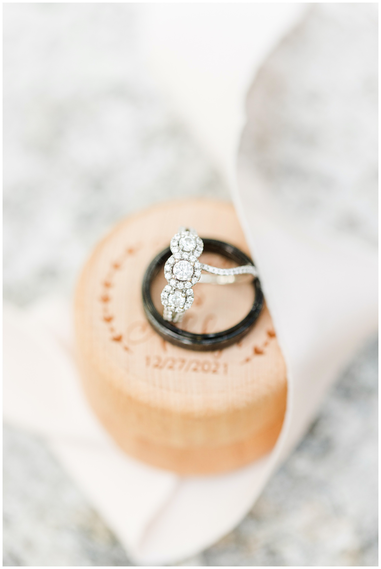 Ashlyn and Thad's three stone wedding bands sit on top of a custom monogrammed wooden ring box | CB Studio