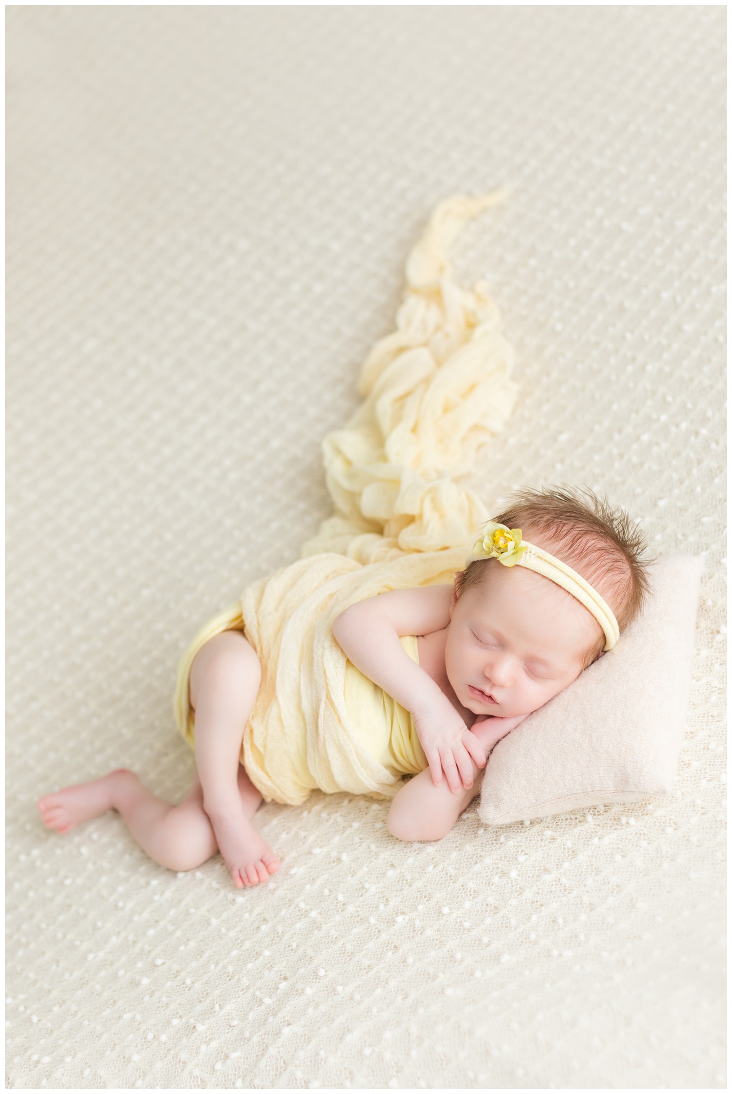 Baby Mackenzie lightly wrapped in yellow sleeping on a cream knit blanket | CB Studio