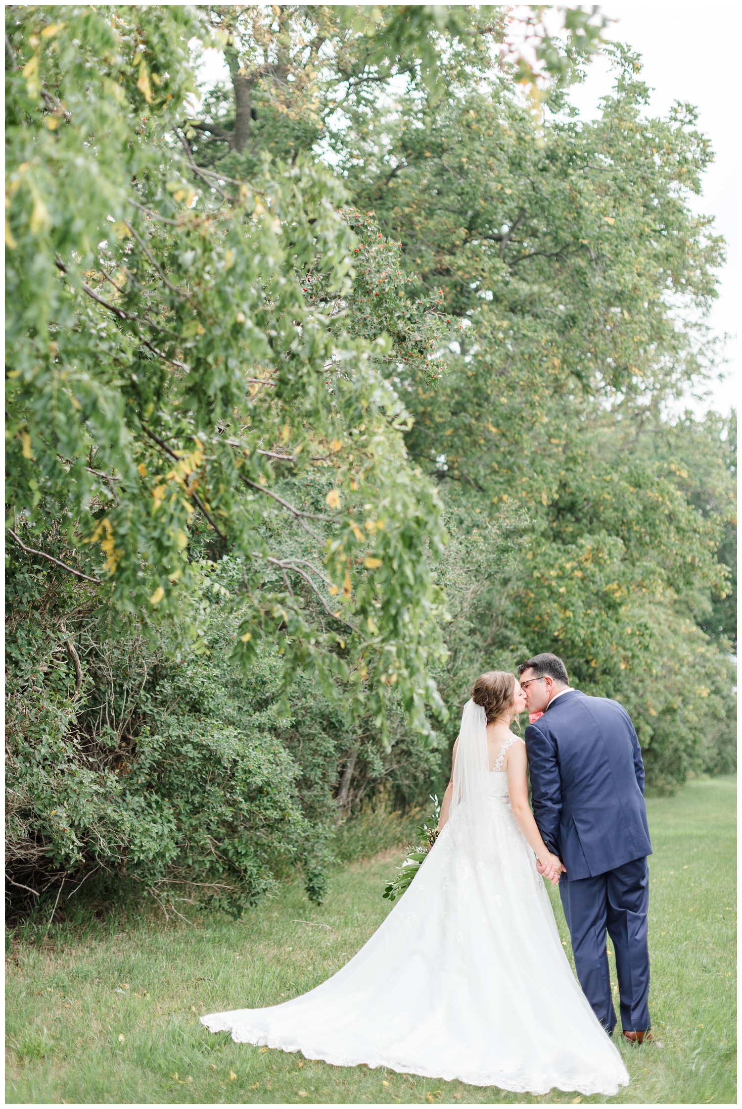 Leslie and Joe stop to share a kiss as they walk through Leslie's grandparent's farm | CB Studio