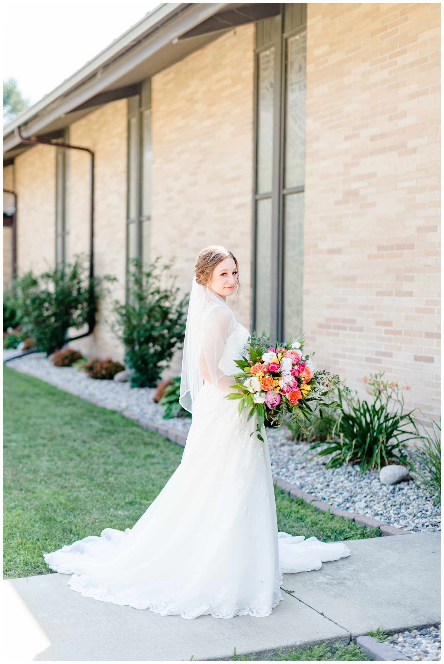 The beautiful bride, Leslie, stands poised in front of the Nazareth Lutheran Church in Armstrong, IA | CB Studio