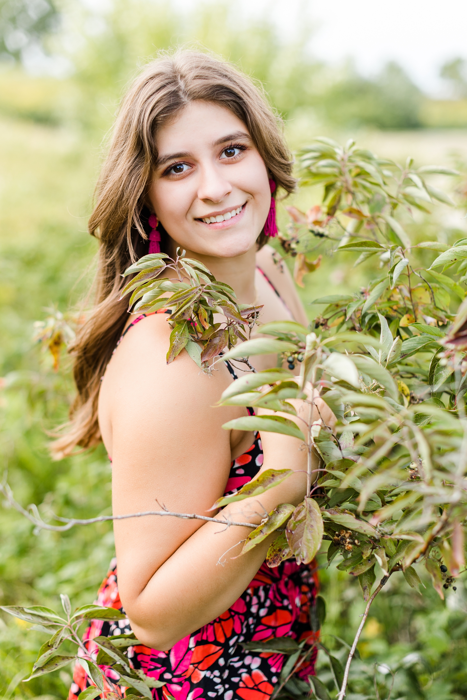 Caitlin smiles in a grassy field at Water's Edge Nature Center | CB Studio