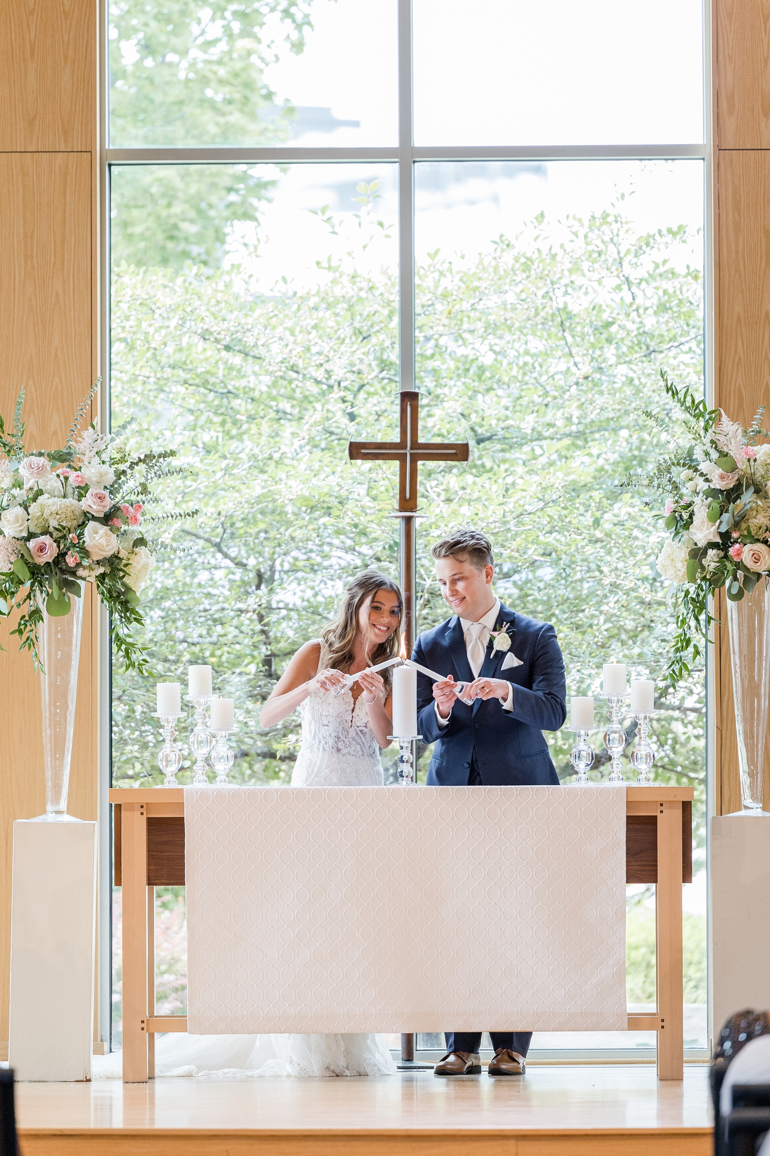 Jadi and Luke light their unity candle during their wedding ceremony at Lutheran Church of Hope in West Des Moines | CB Studio