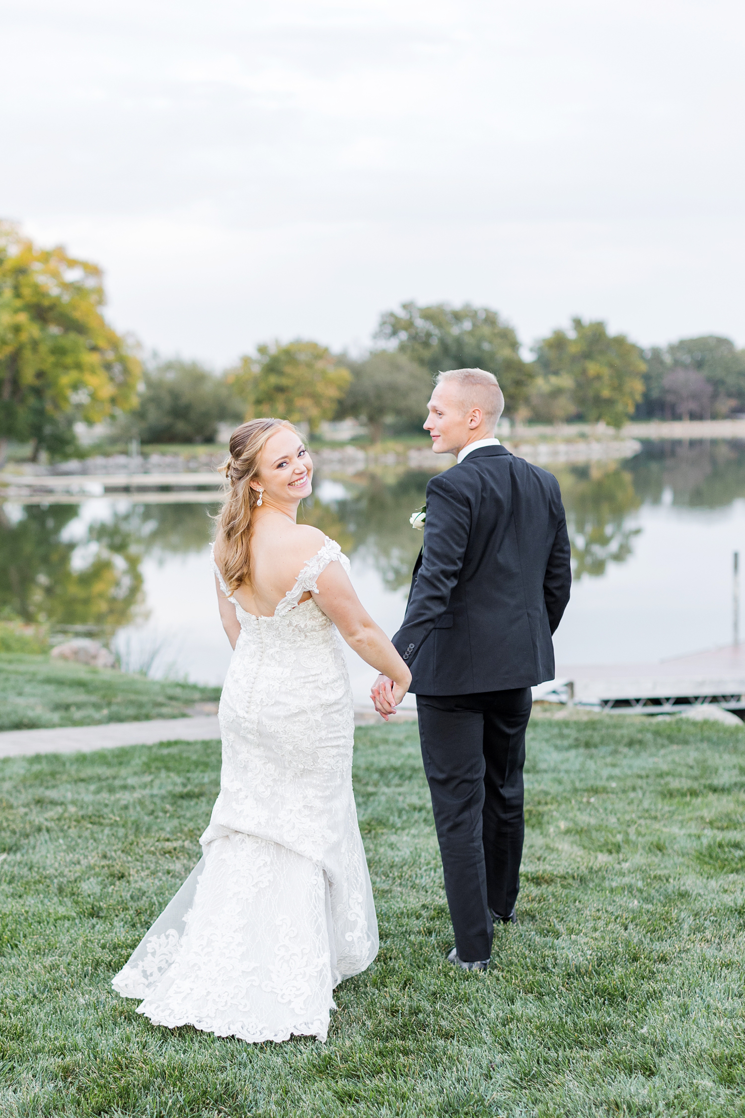 Newly married Brenna and Jacob walk out to the dock at The Shores at Five Islands | CB Studio