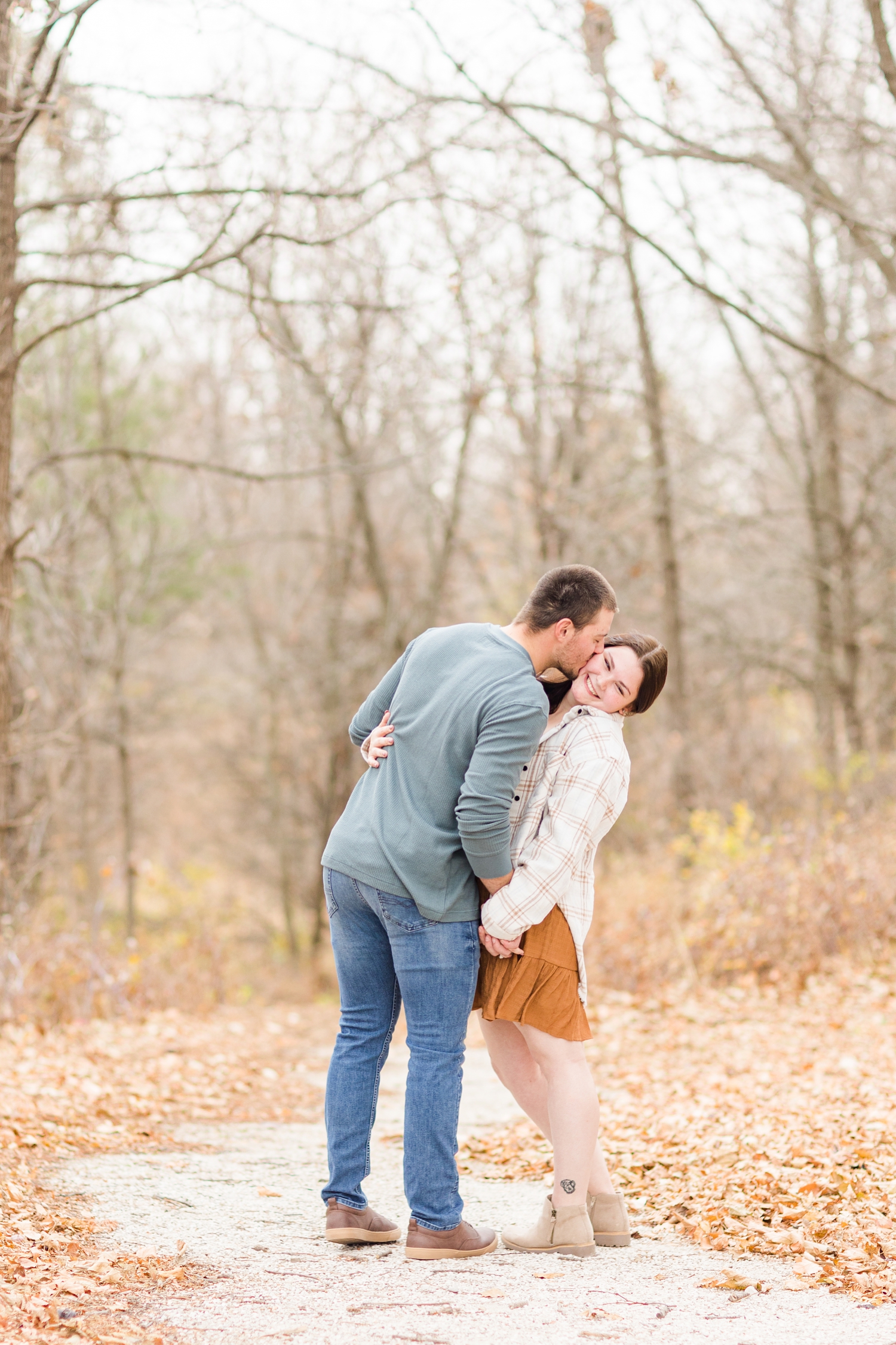Austin leans in to kiss Mary's cheek during their engagement photography session at Kennedy Park in Fort Dodge, IA | CB Studio