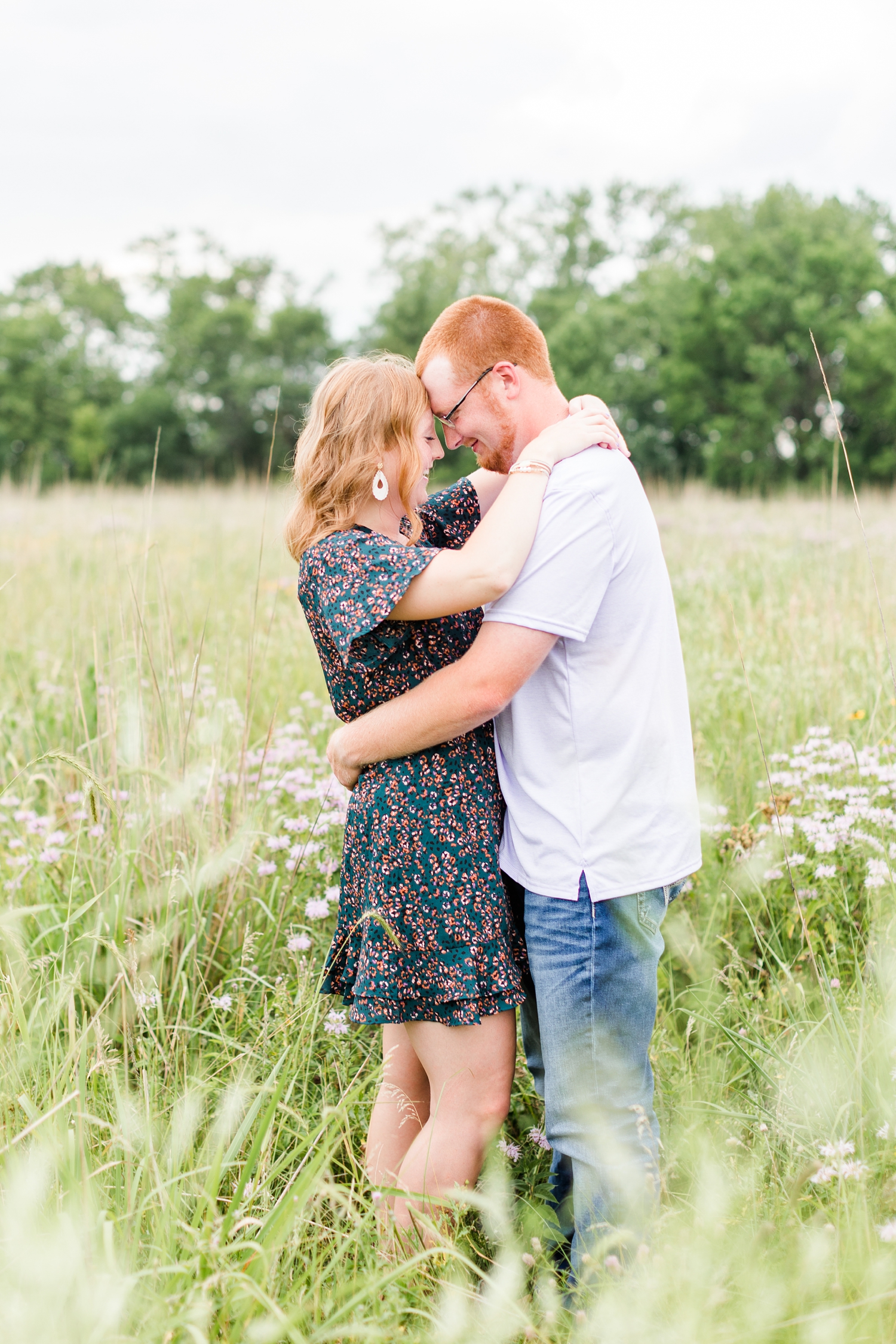 Lauryn and Matt embrace in the middle of a wildflower field in rural Iowa. | CB Studio