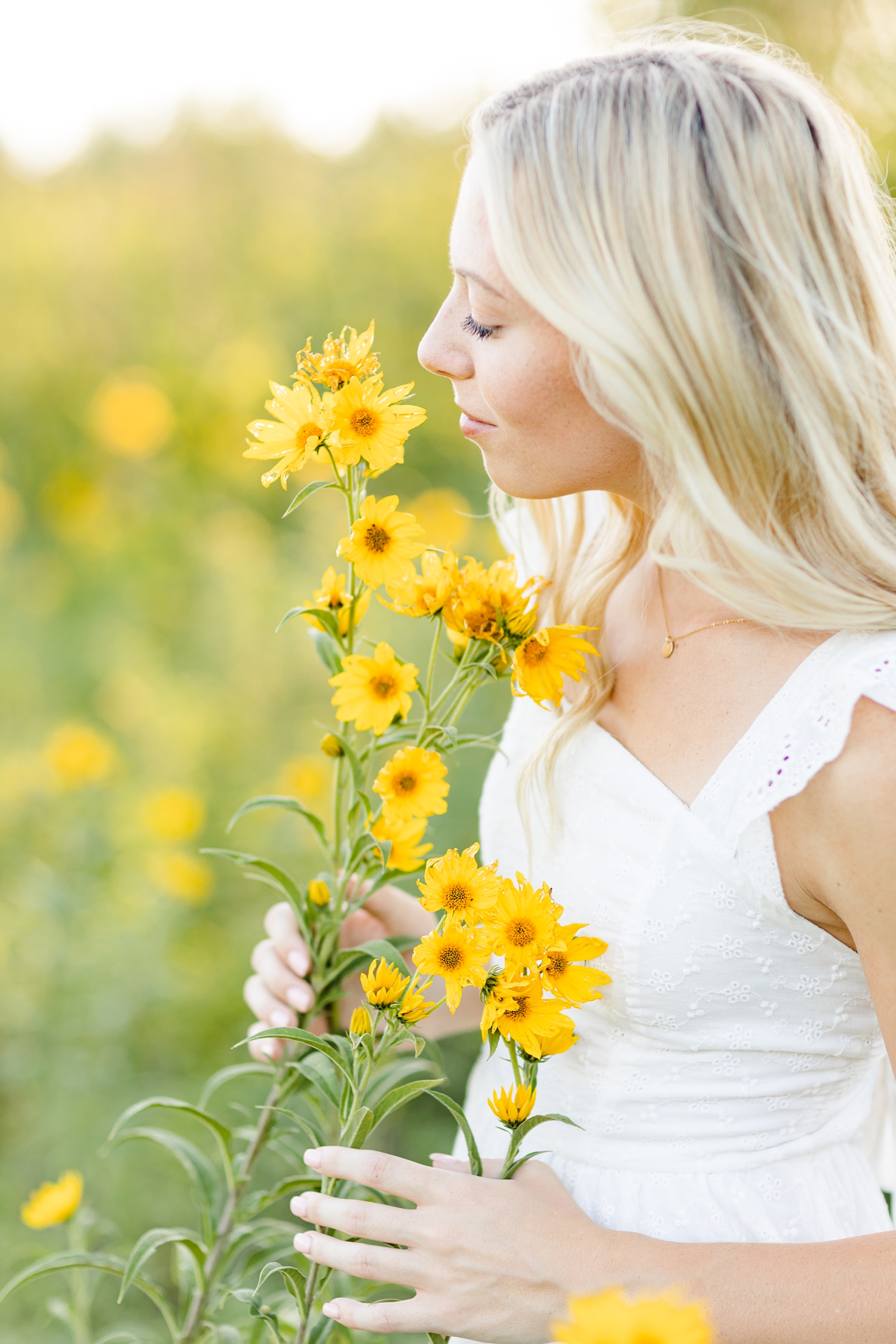Shelby softly smells beautiful yellow flowers in a field of wildflowers | CB Studio