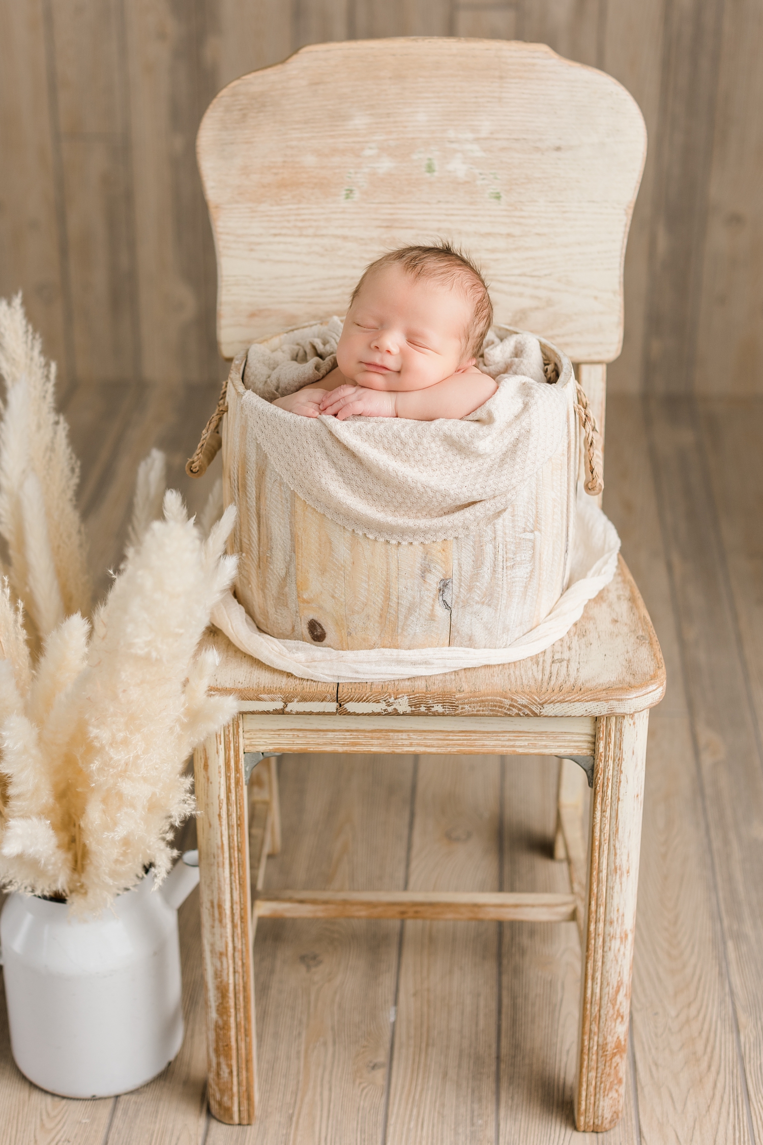 Baby Rhett nestled in a boho cream bucket surrounded with pampas grass | CB Studio