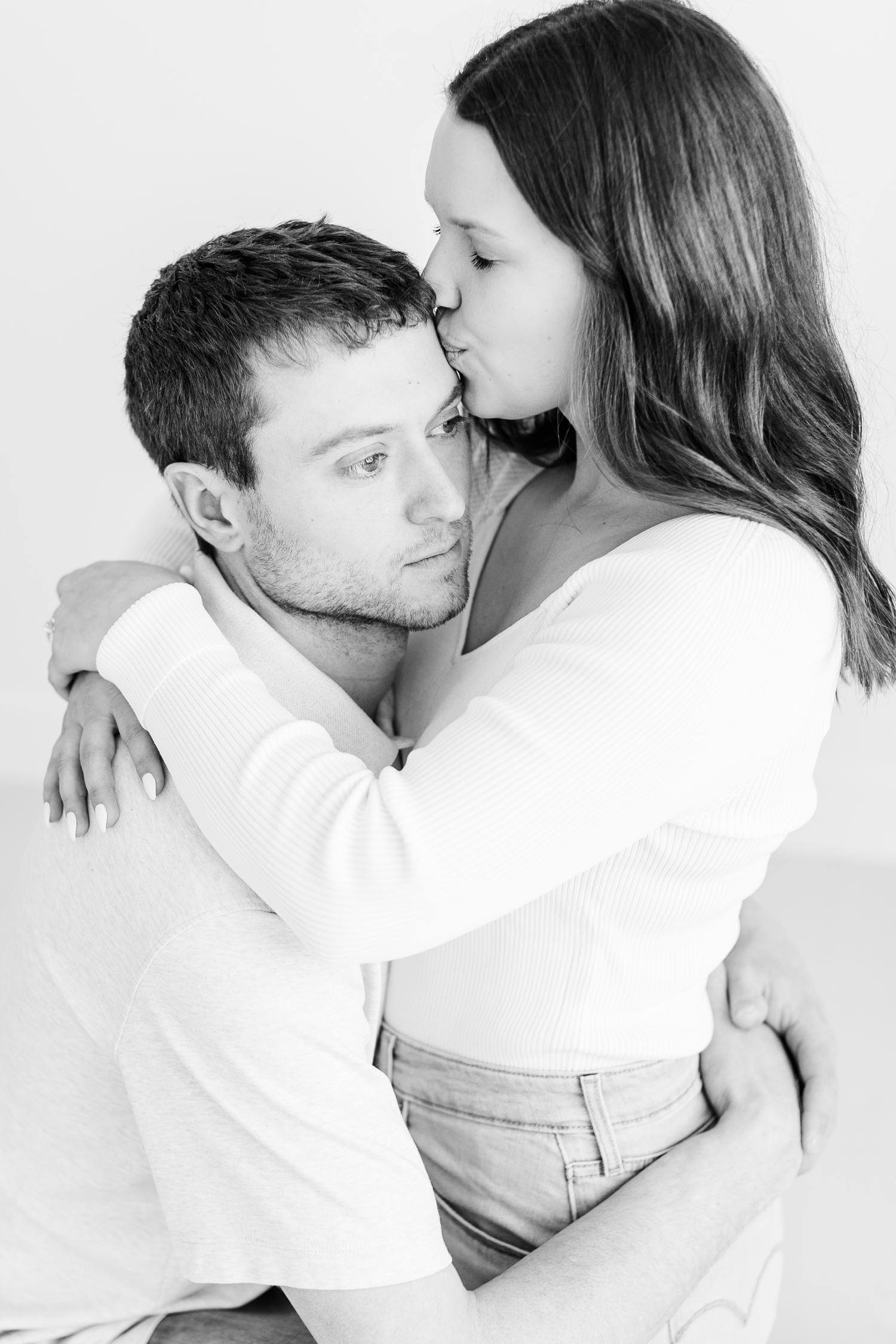 Grant hugs his bride to be, Alyssa, as she kisses his forehead | Iowa Wedding Photographer | CB Studio