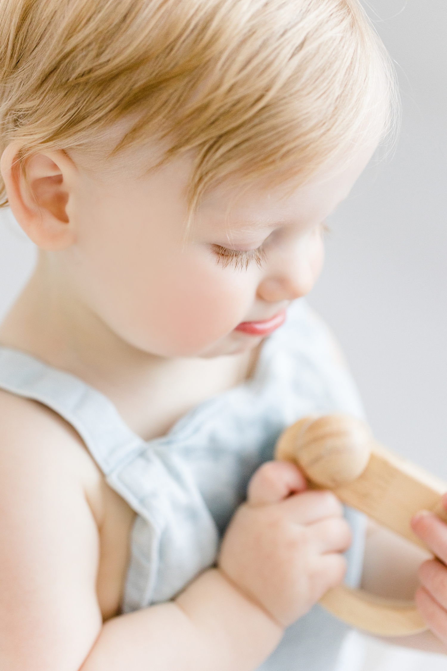 Detail image of Baby Brody's long eyelashes as he looks down at a wooden toy car | CB Studio