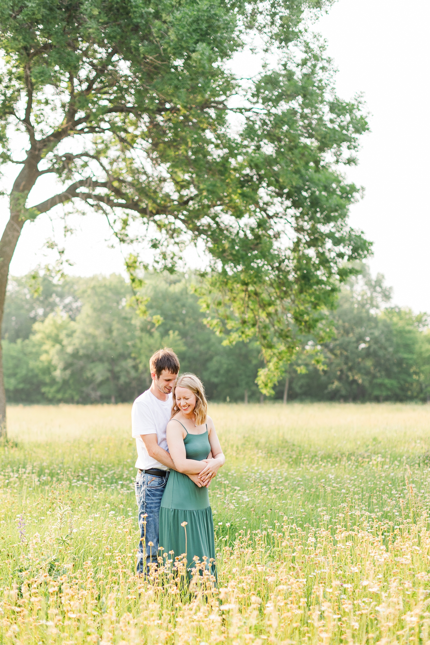 Zane holds tightly to his future bride as they stand in a wildflower field | CB Studio