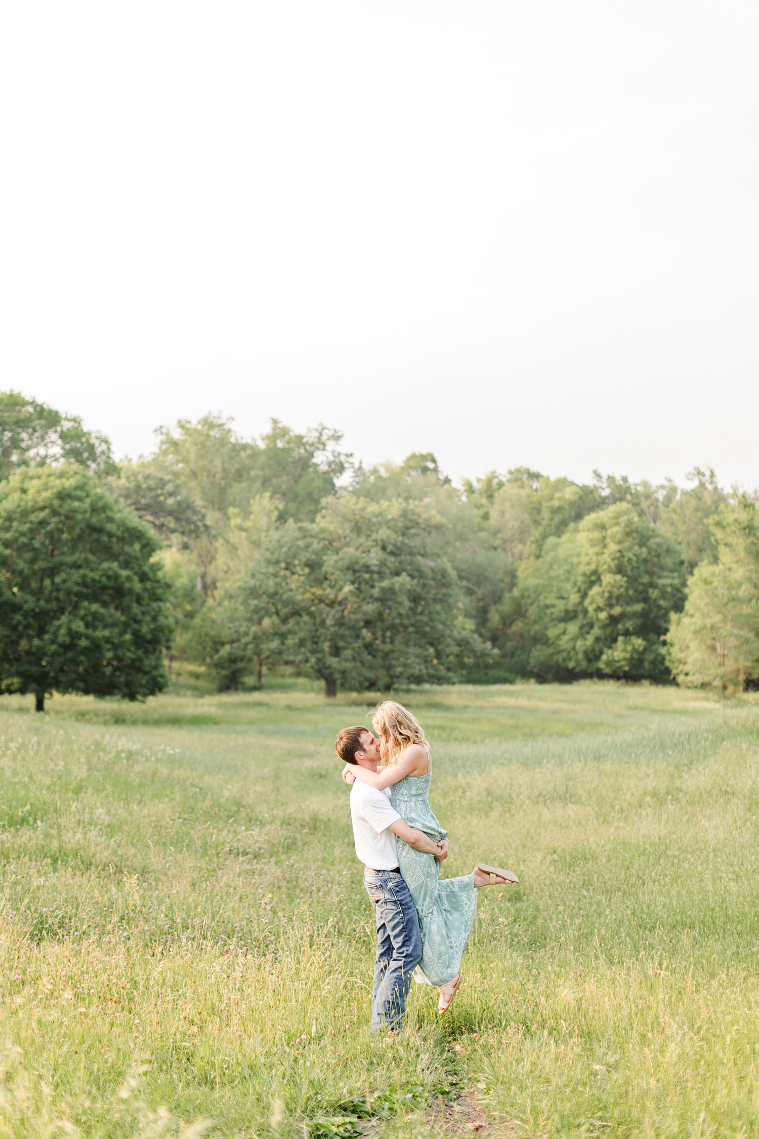 Zane picks McKennan off her feet and kisses her in a grassy field | CB Studio