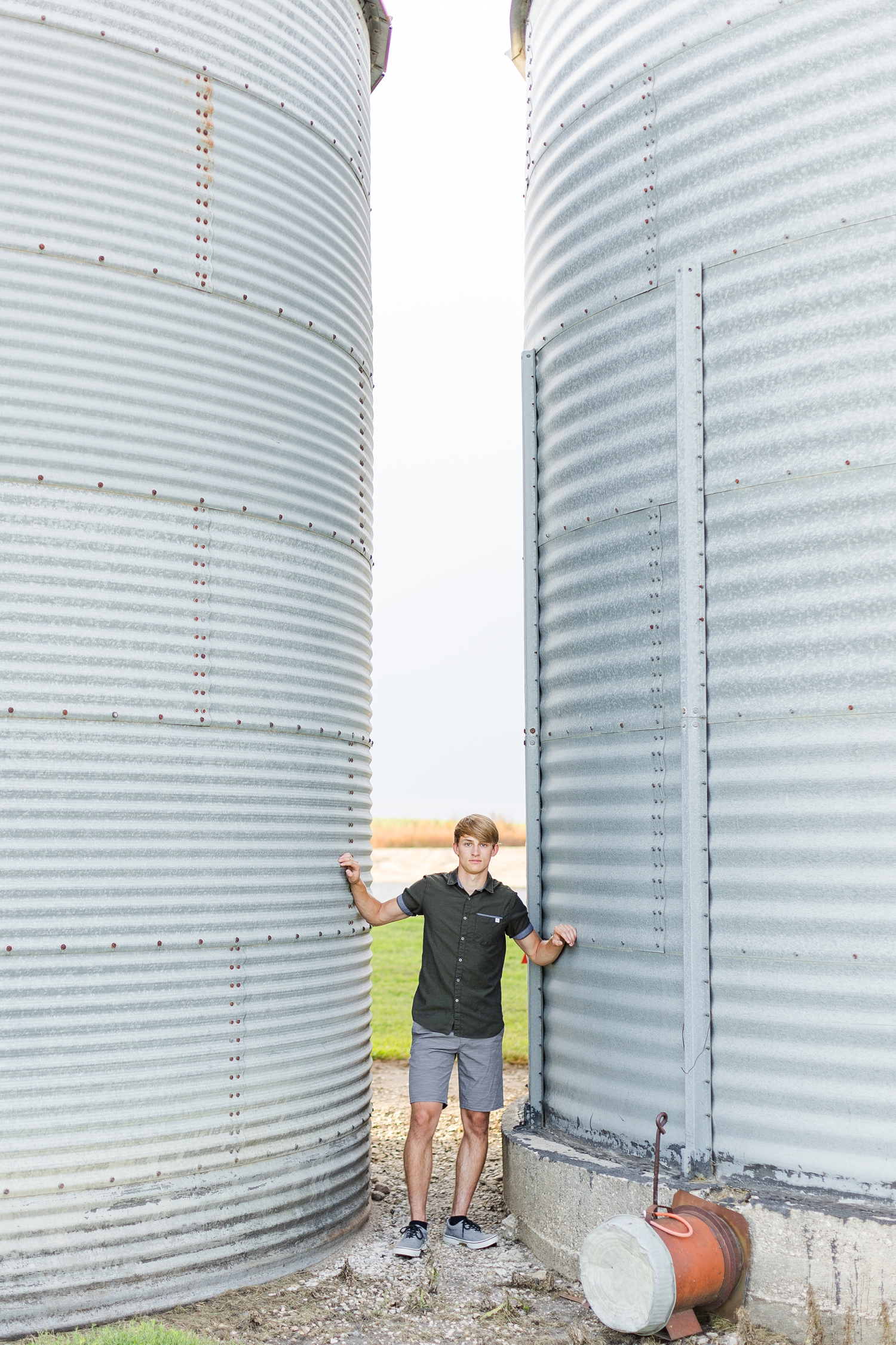 Aidan stands in between two grain bins while pushing his arms against the walls | CB Studio