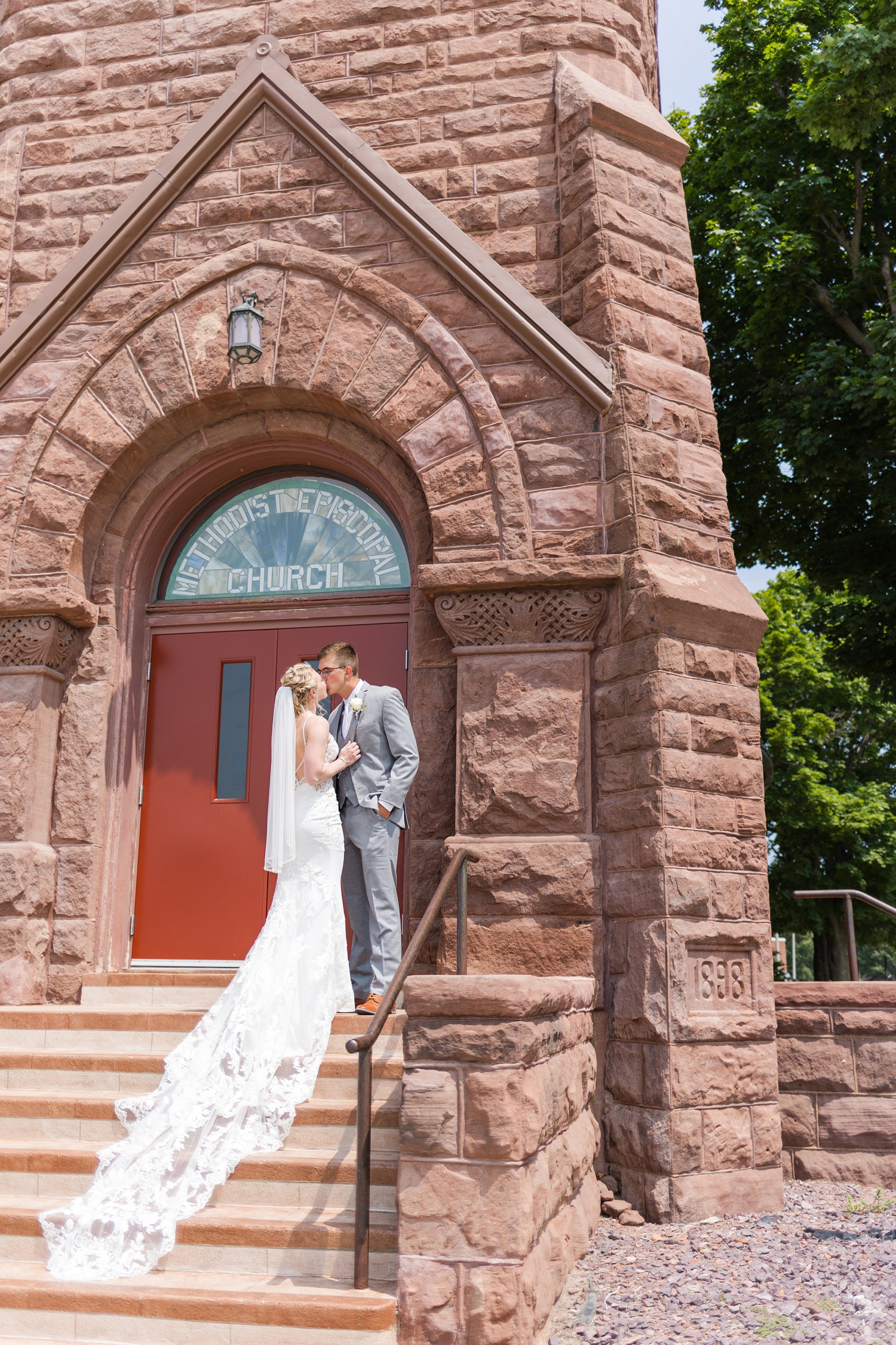 Quinton and Alli share a kiss on the front steps of the First United Methodist Church in Algona before their wedding ceremony | CB Studio