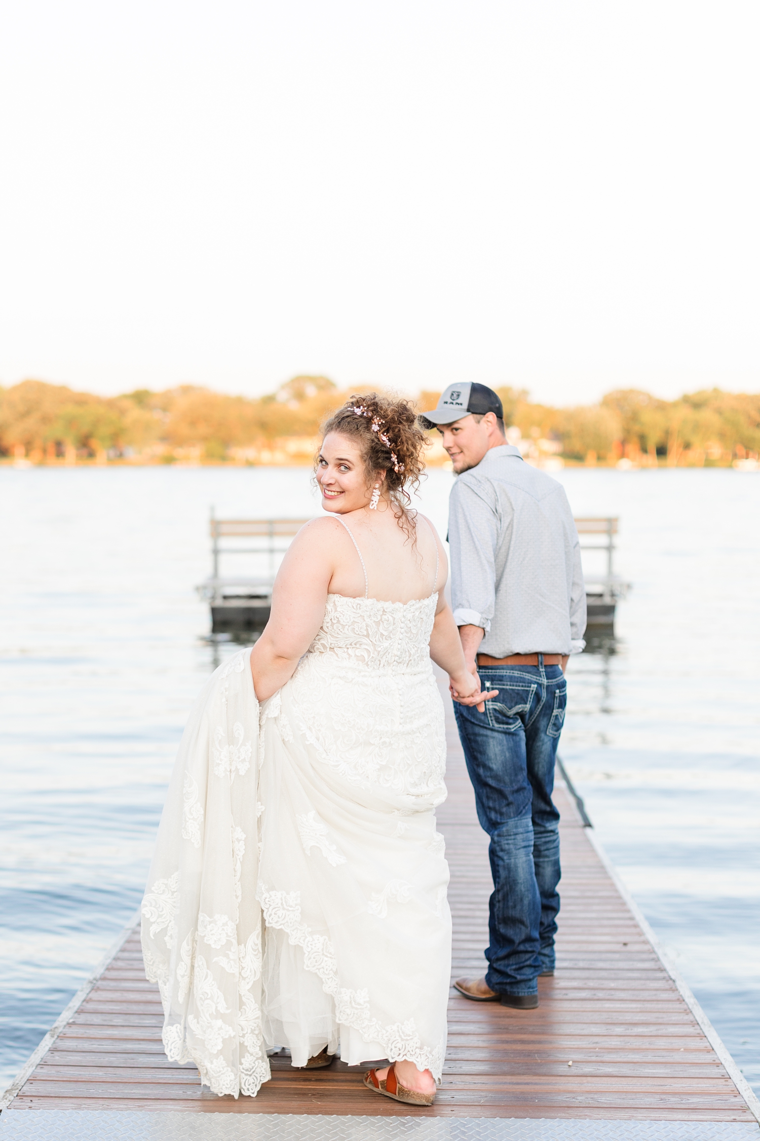 Dakota leads his new bride out on the dock at The Shores at Five Island at sunset | CB Studio