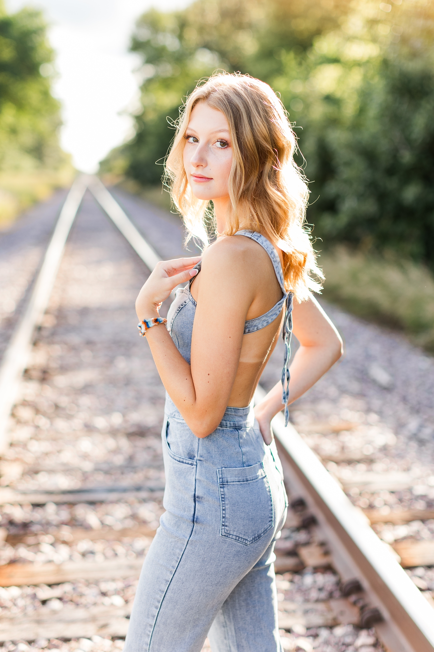 Ryley stands on railroad tracks and looks over her shoulder | CB Studio