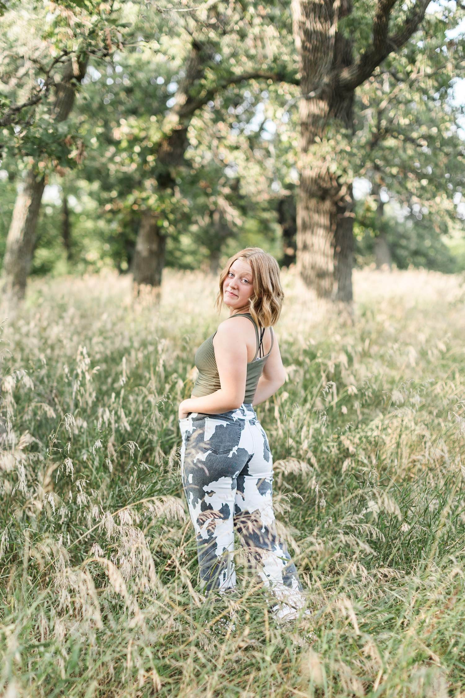 Kenzie looks back as she walks through a grassy field | CB Studio