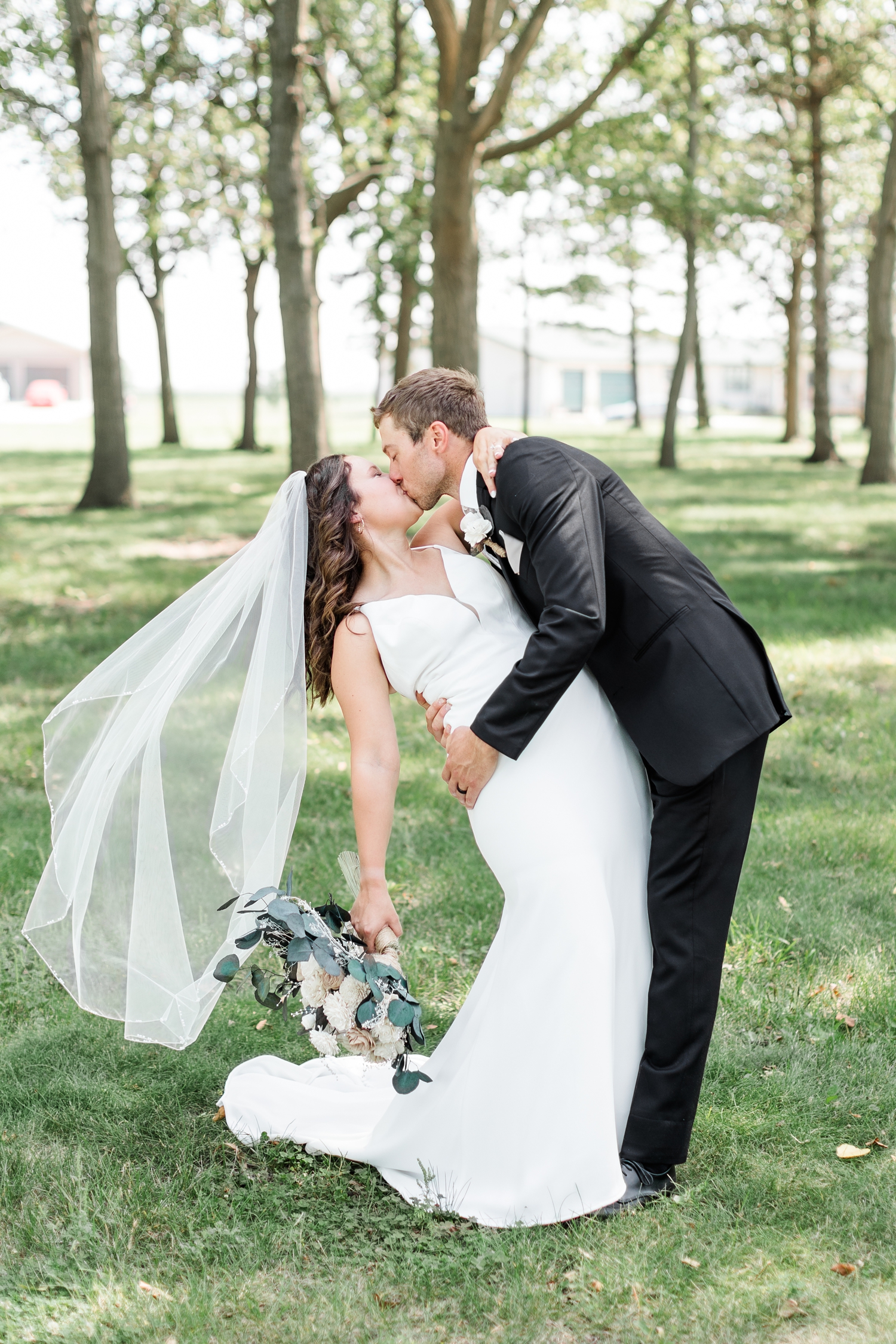 Grant dips his bride Alyssa for a kiss at 5 Island Campground in Emmetsburg, IA | CB Studio