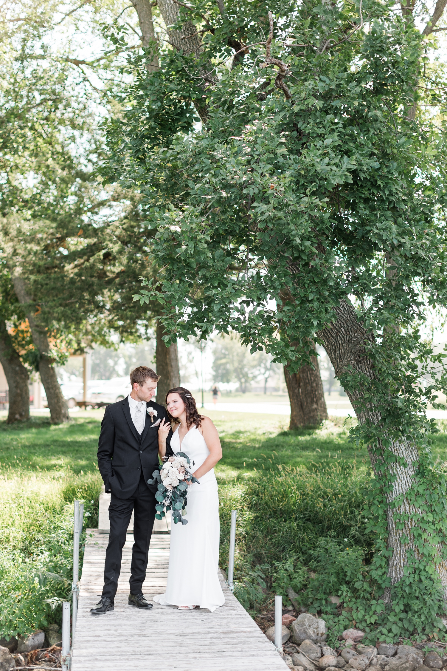 Grant and Alyssa stand together on a lake dock at 5 Island Campground in Emmetsburg, IA | CB Studio
