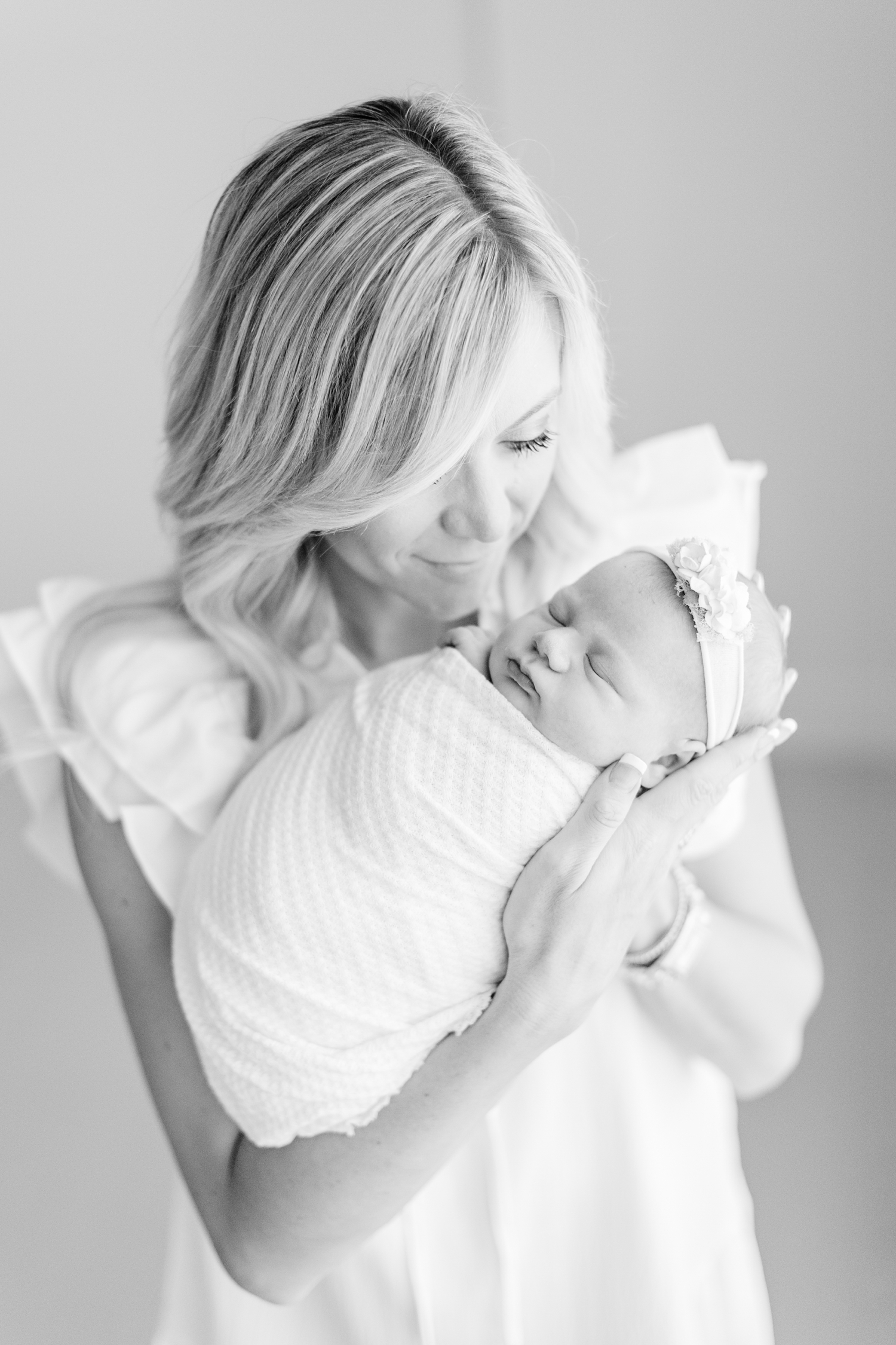 Ashley holds her new baby girl, Jade, as she's swaddled up in white cloth | CB Studio