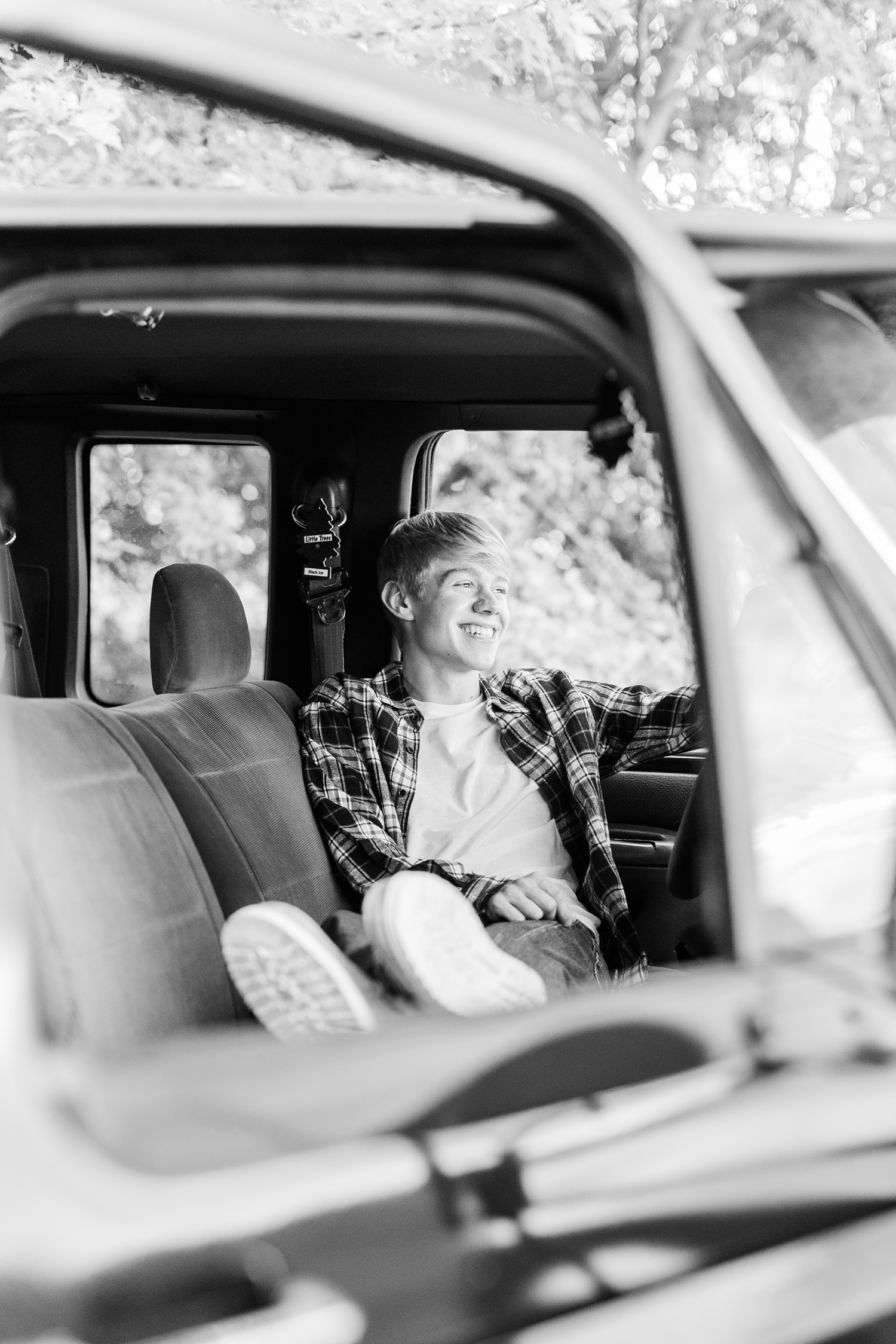 CJ smiles as he relaxes in the driver's seat of his black ford truck | CB Studio