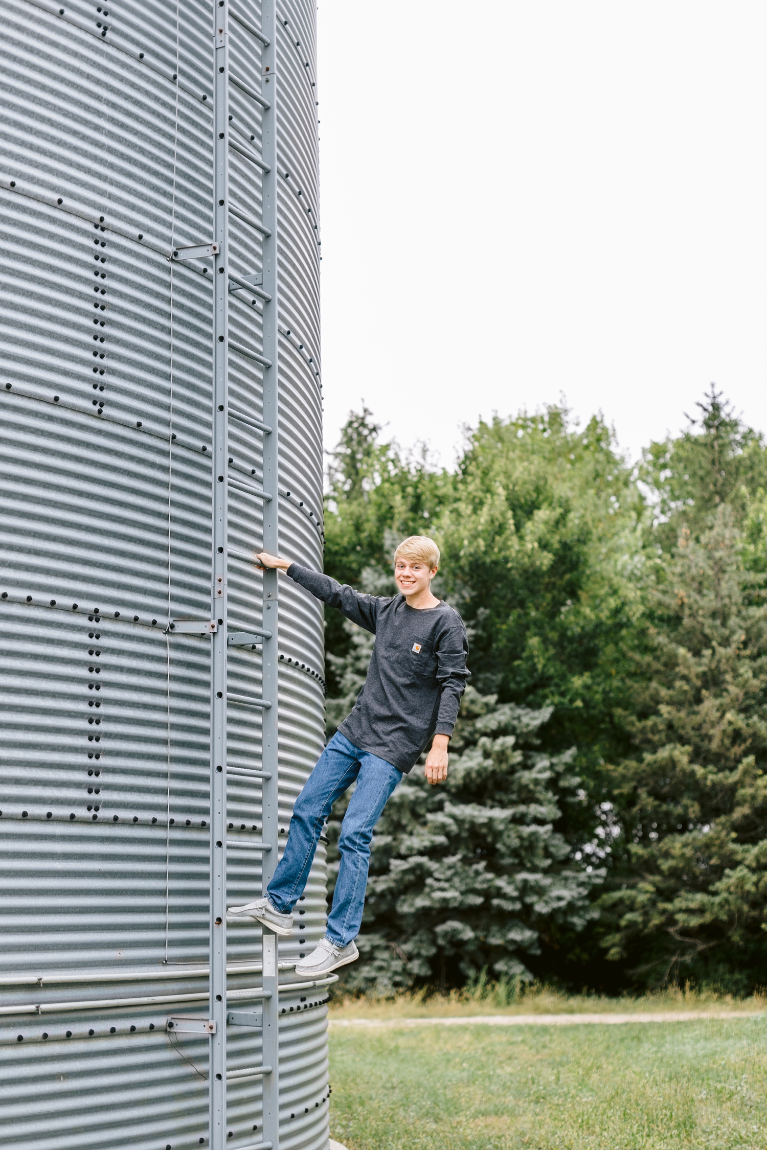 CJ hangs off the side of a ladder on a grain bin at his grandpa's farm in northern Iowa | CB Studio
