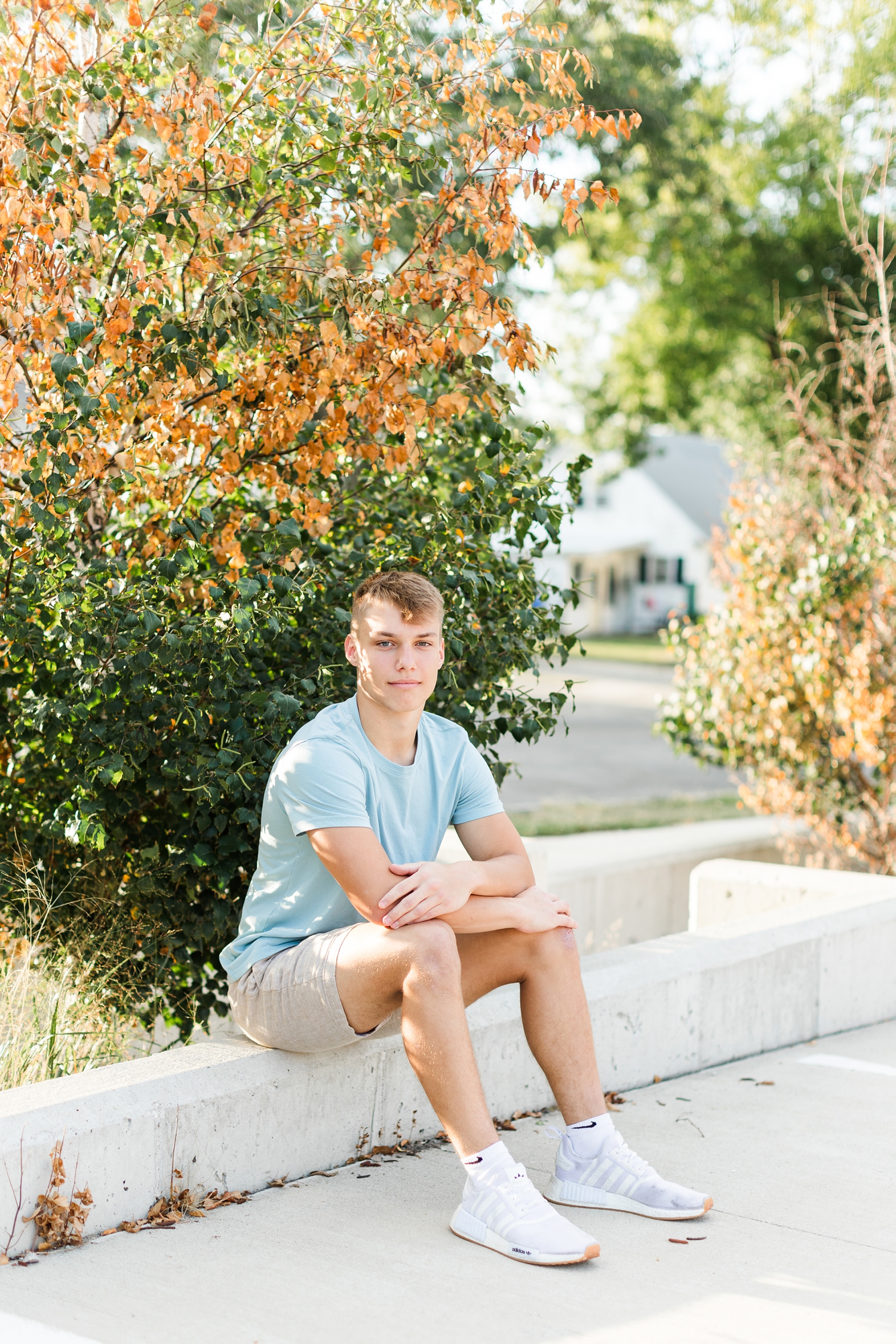 Matt sits in a parking lot lined with trees just starting to turn in to fall color in downtown Algona | CB Studio