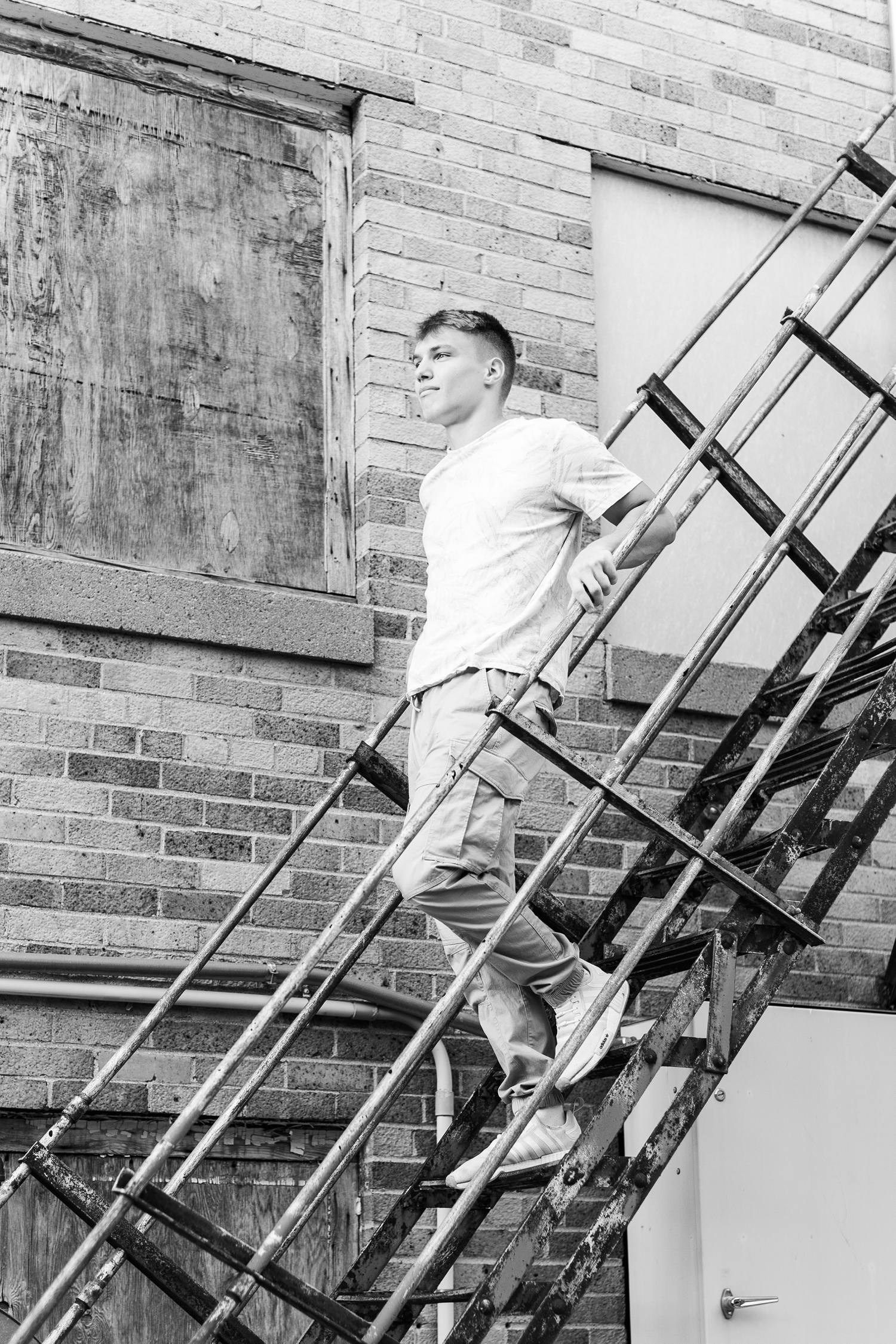 Matt walks down a rustic metal staircase in downtown Algona, IA | CB Studio