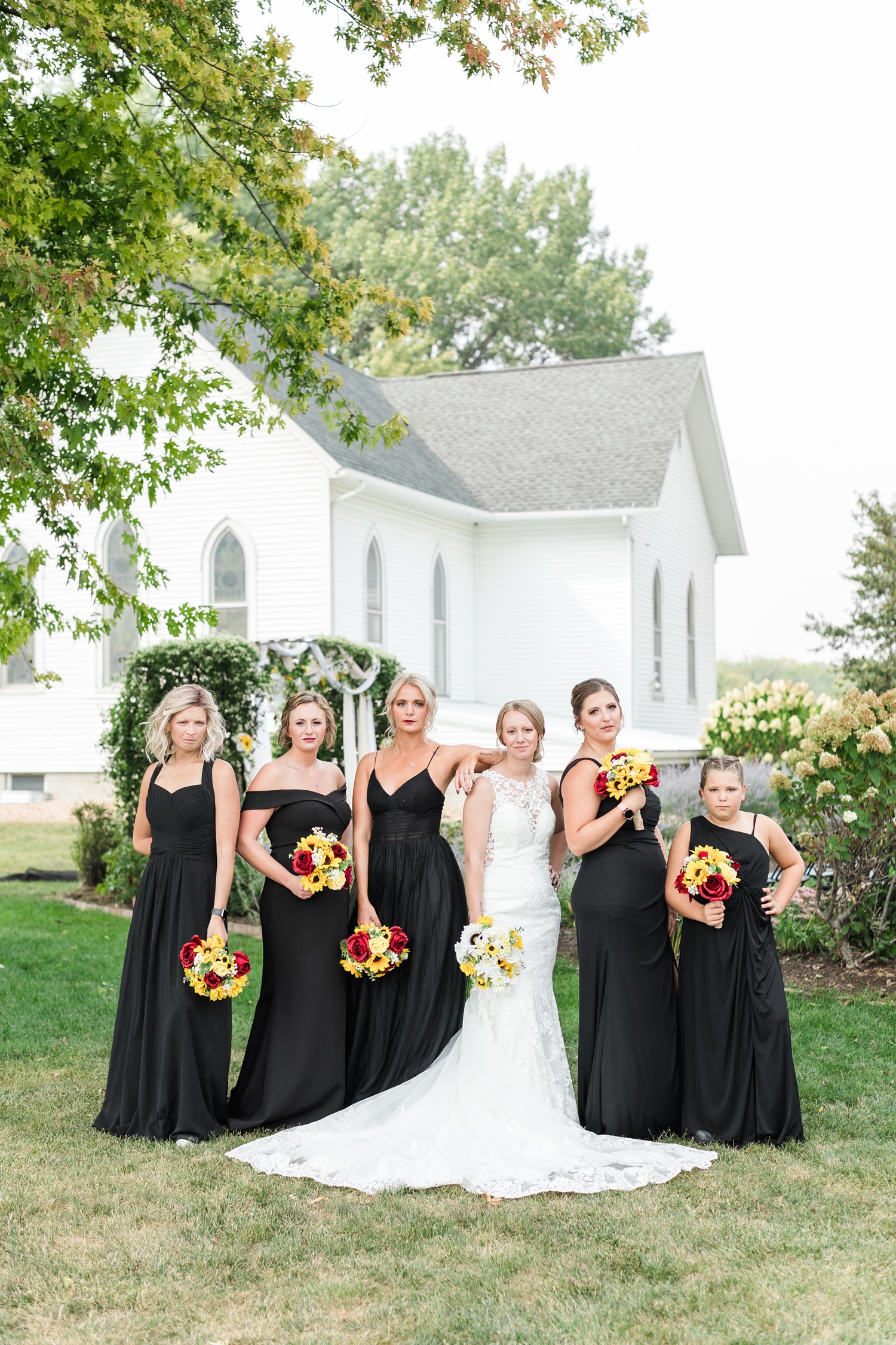 Mckennan and her bridesmaids model pose in the garden space at the Humboldt County Museum with the Hardy church in the background | CB Studio