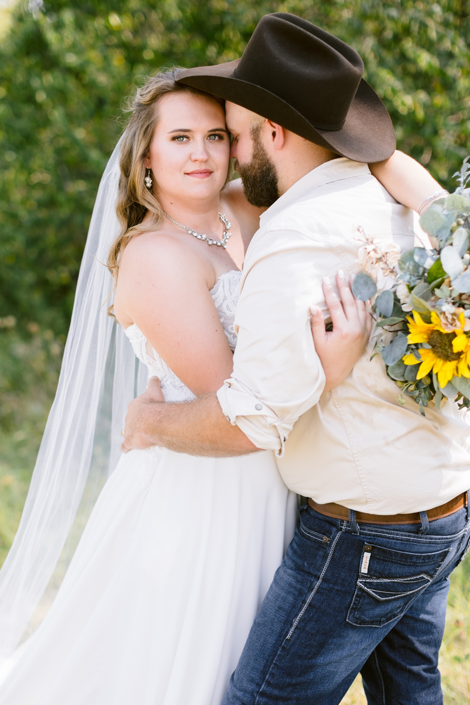 Matt nuzzle his bride, Megan, close as she stares into the camera | A rustic, country wedding with western touches | CB Studio