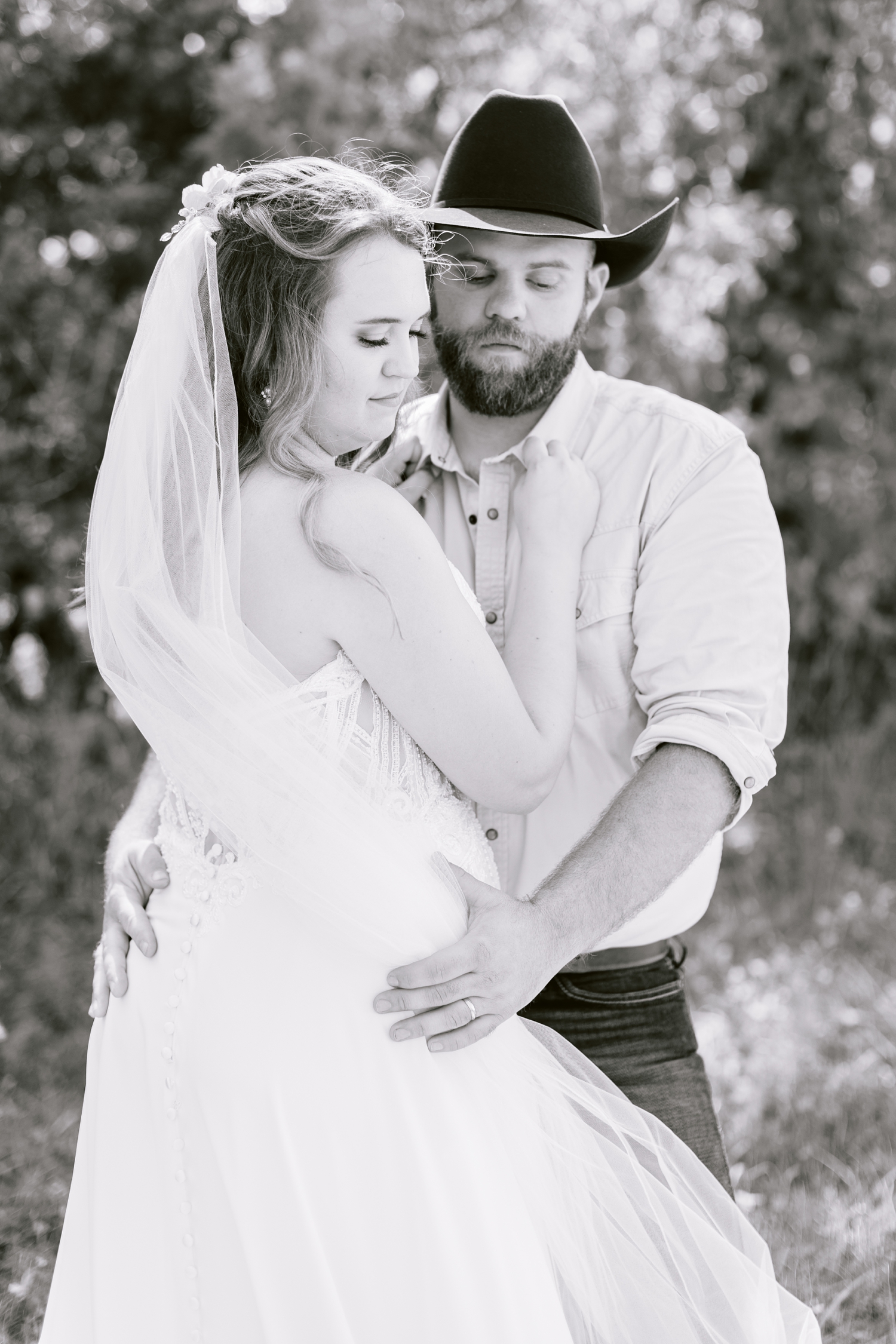 Matt holds his bride, Megan, close as they look down | A rustic, country wedding with western touches | CB Studio
