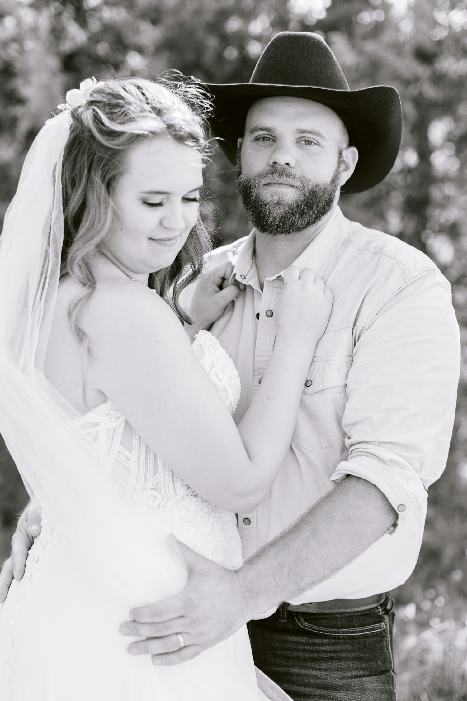 Matt holds his bride close as she looks down over her shoulder | A rustic, country wedding with western touches | CB Studio