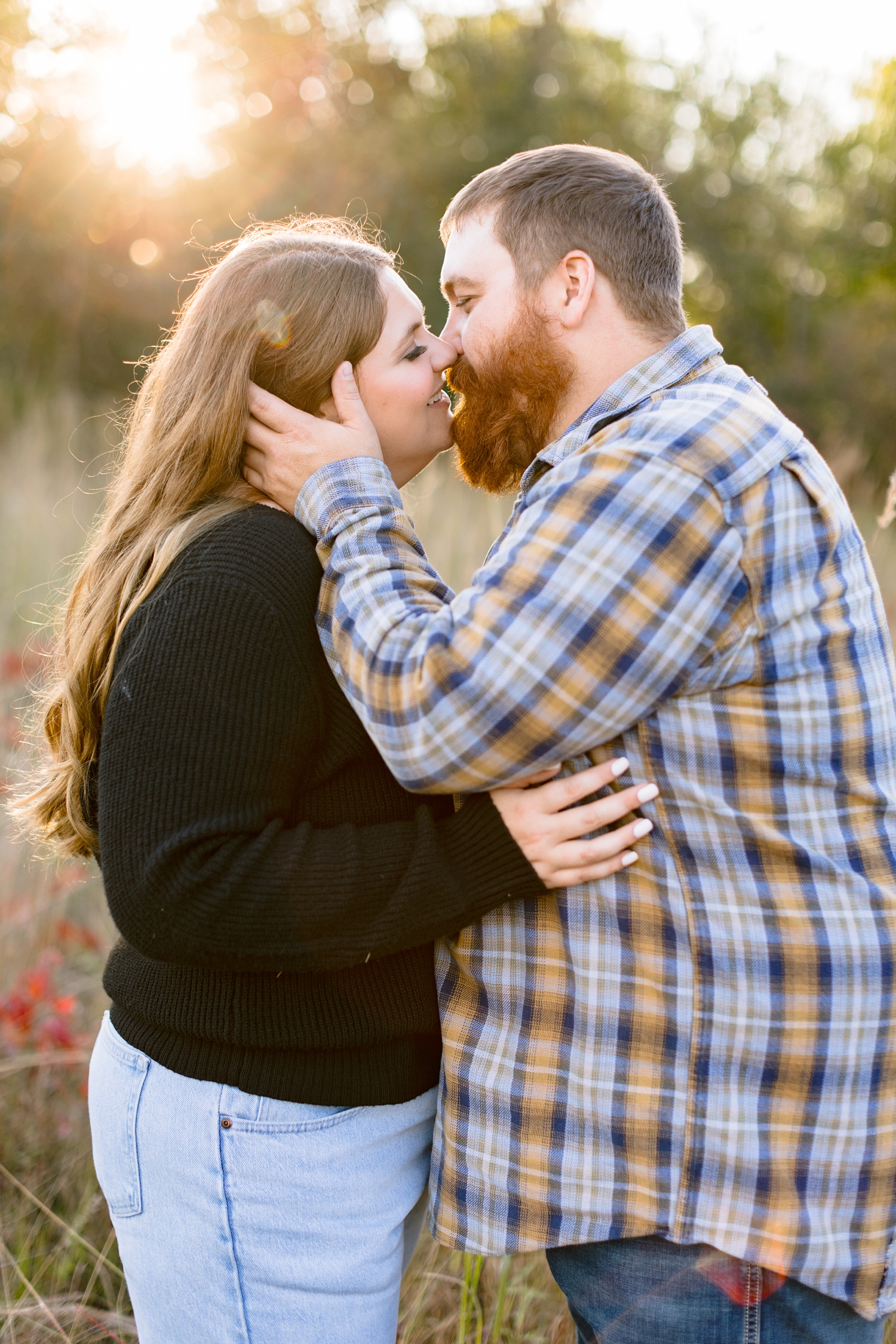 Trent slowly kisses his bride-to-be during golden hour surrounded by fall foliage at Sheldon Park in Humboldt, IA | CB Studio