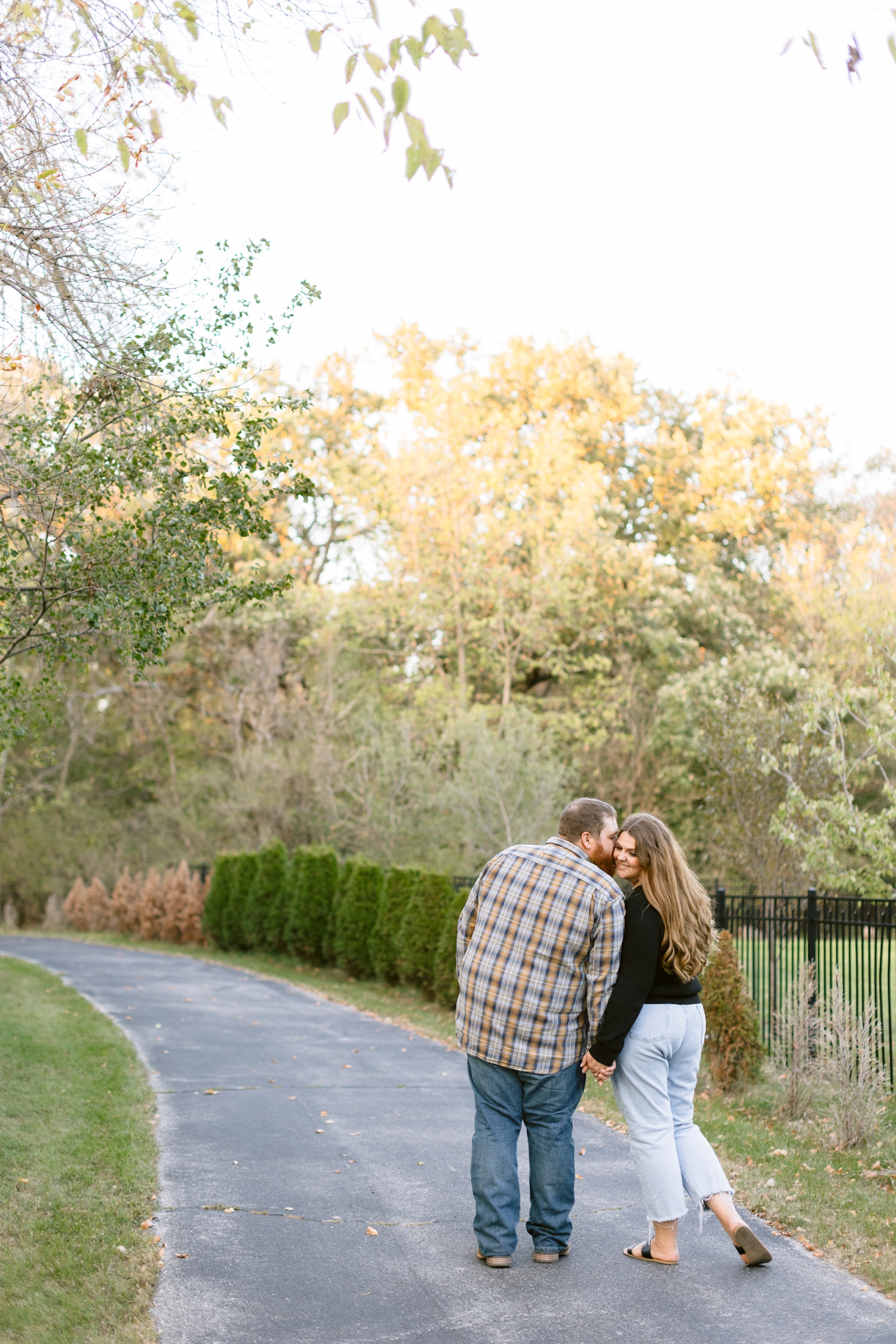 Trent kisses his bride-to-be on the cheek as they walk down the Cottonwood Trail in Humboldt, IA | CB Studio