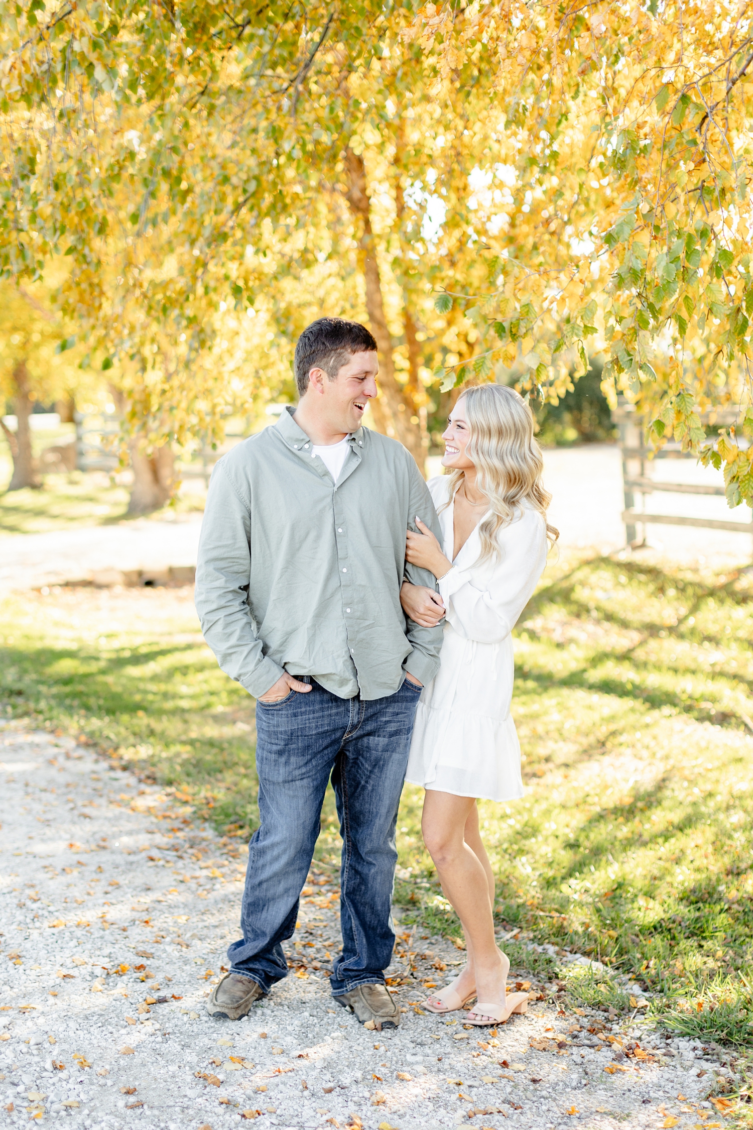 Reed and Nicole smile at each other along a row of golden birch trees at River Vally Orchards & Winery | CB Studio