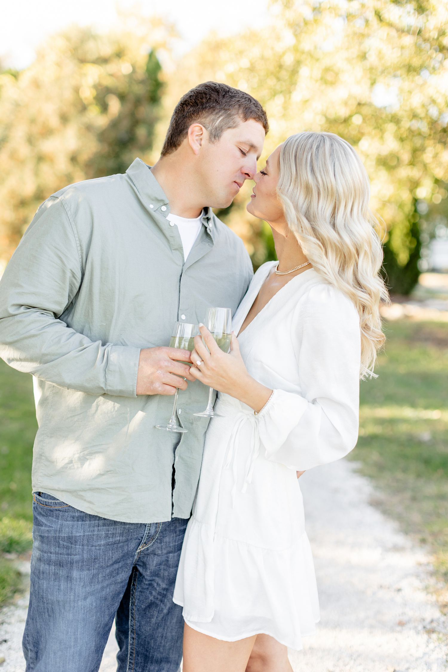 Reed and Nicole hold wine glasses as they are about to kiss at River Vally Orchards & Winery | CB Studio