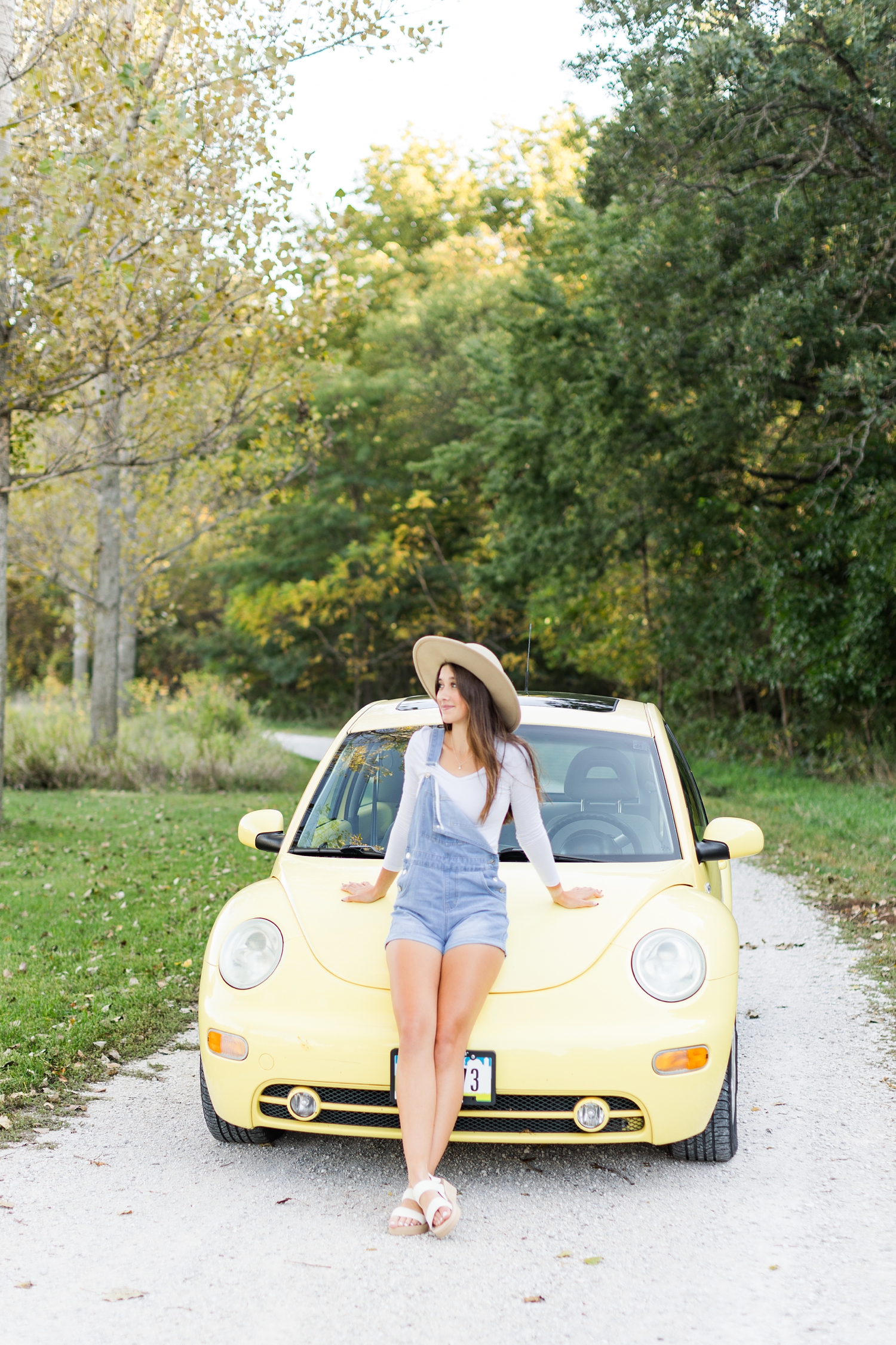 Sarah leans against the hood of her yellow VW Beetle in Sheldon Park in Humboldt, IA | CB Studio
