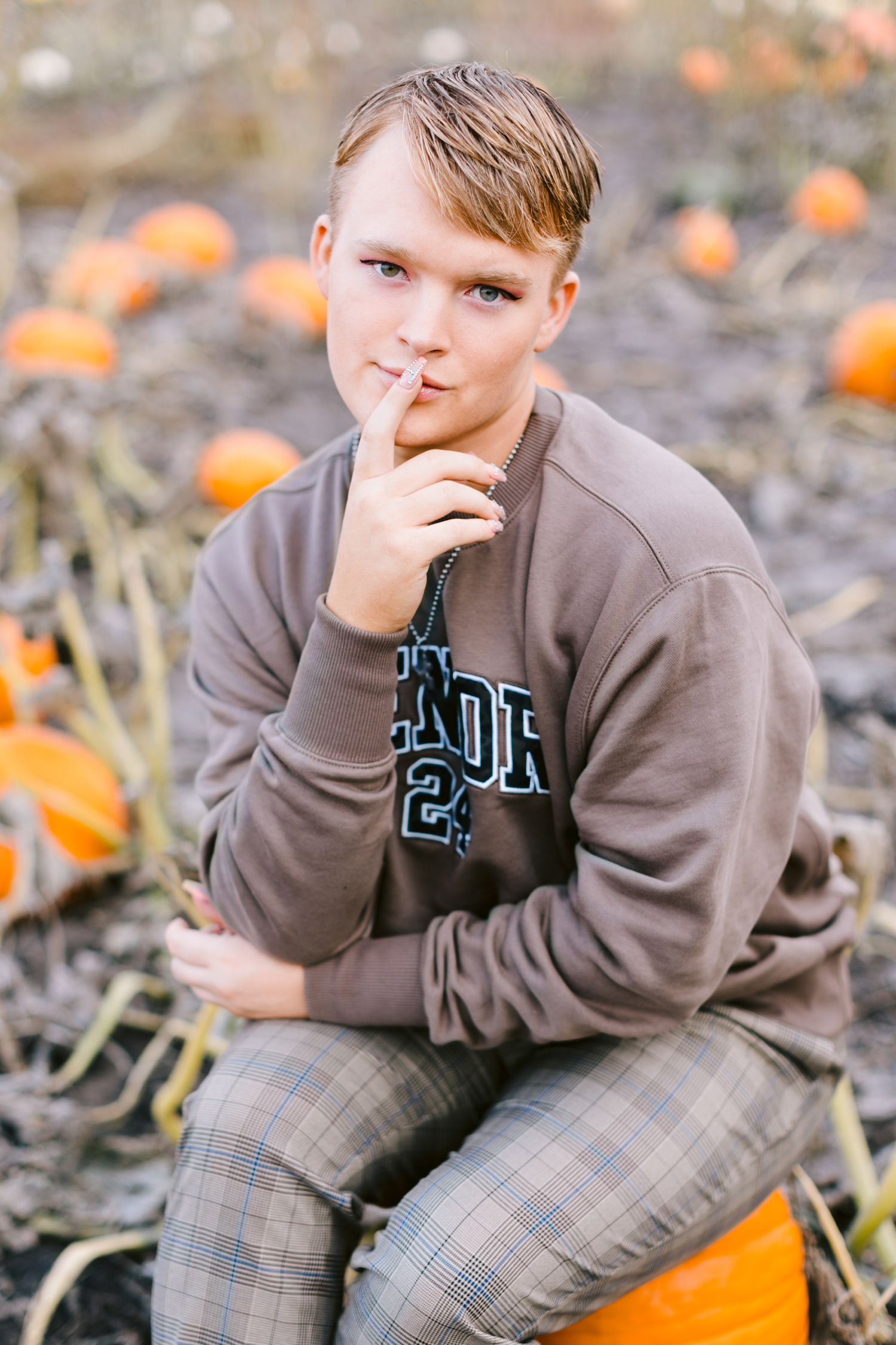 Seth sits on a pumpkin in the middle of a pumpkin field at Bode's Moonlight Farm | CB Studio