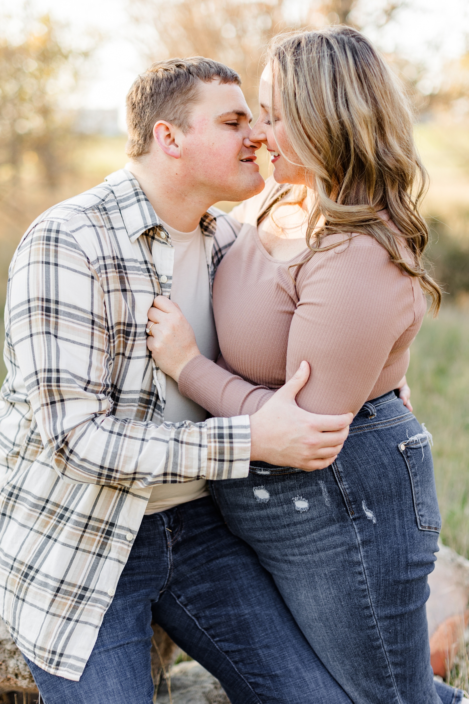 Shelby and Taylor embrace each other and about to share a kiss in a grass pasture in Iowa | CB Studio