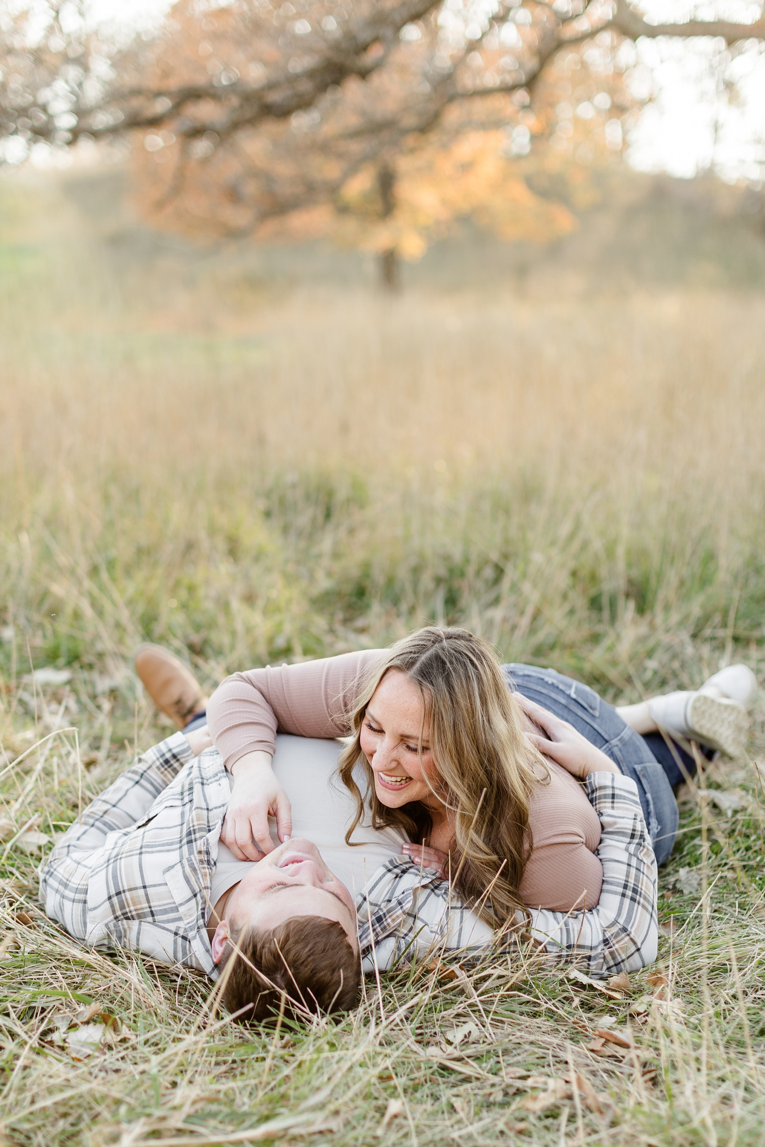 Shelby, while laughing at Taylor, together they lay down in a grass pasture in Iowa | CB Studio