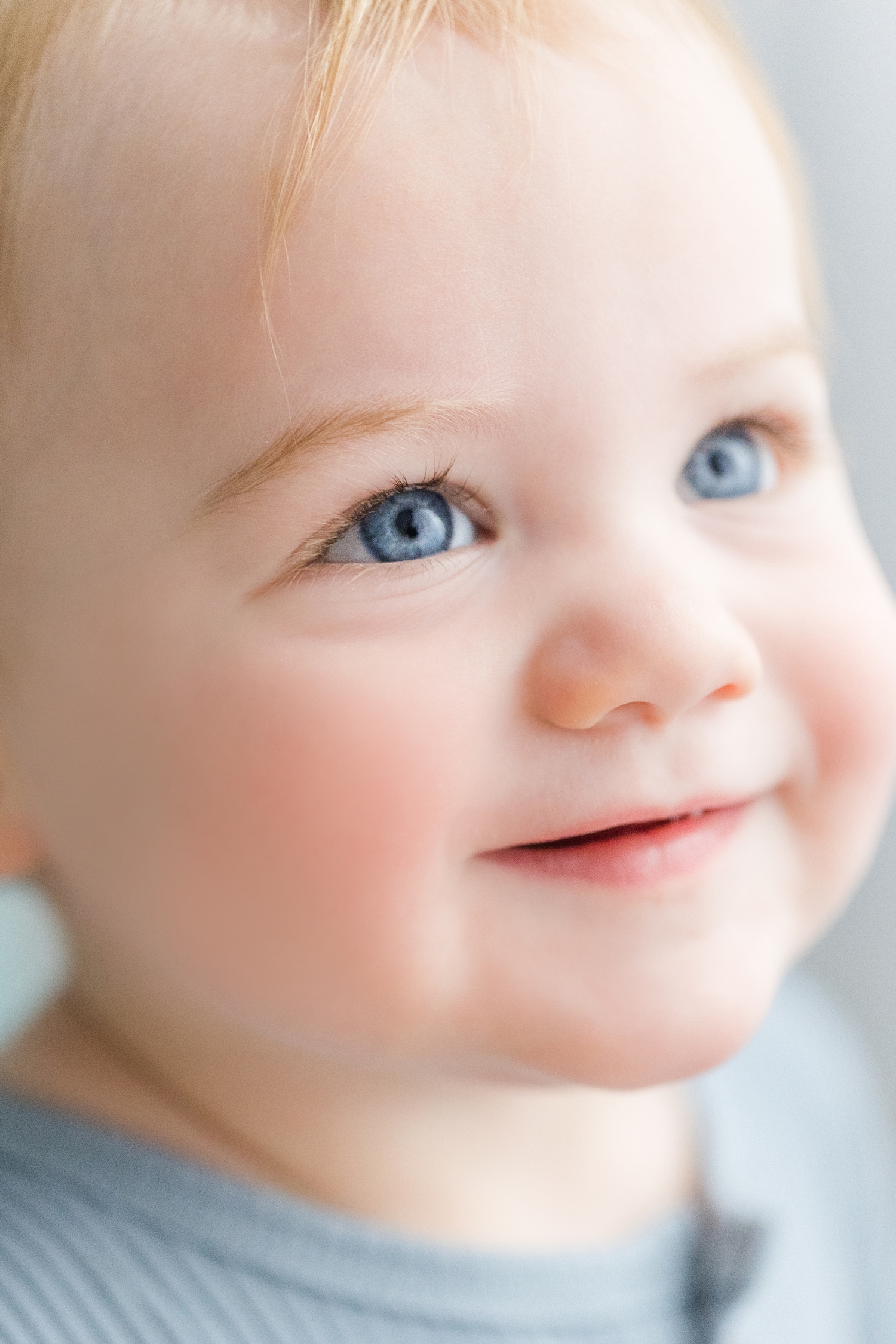 Closeup details of Baby Lewis's smiling face and bright blue eyes | CB Studio