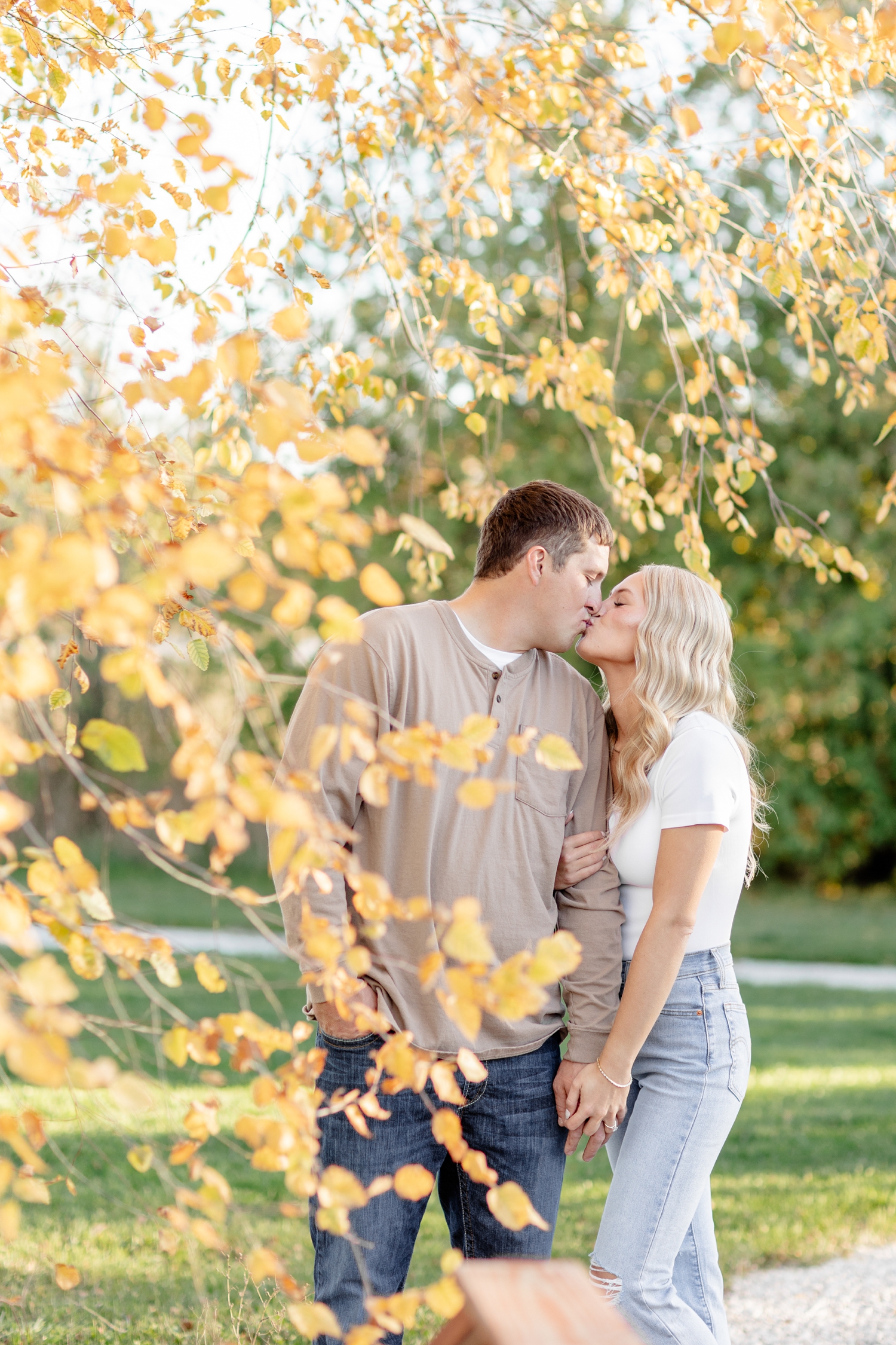 Reed and Nicole share a kiss as they are surrounded by yellow and orange birch leaves | CB Studio