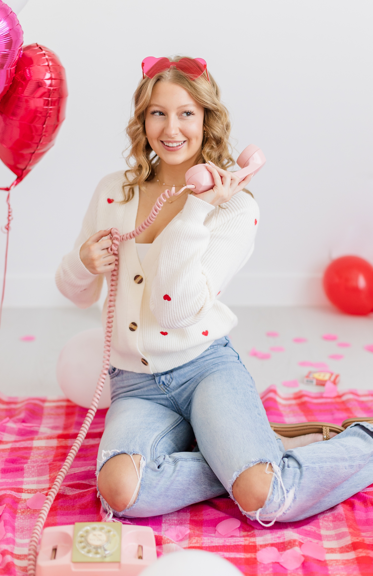 Ryley talks on her pink rotary phone while she twirls on the curly cord during a Galentine's styled photoshoot | CB Studio