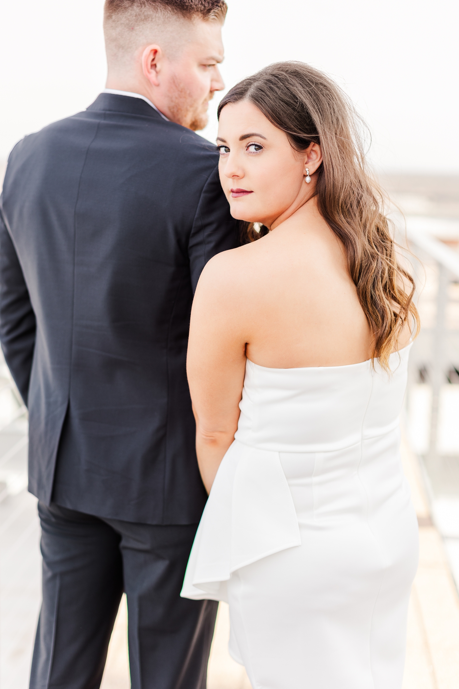 Jenna leans into Dustin's shoulder as she looks over her shoulder into the camera The Equitable Building in Des Moines, IA | CB Studio