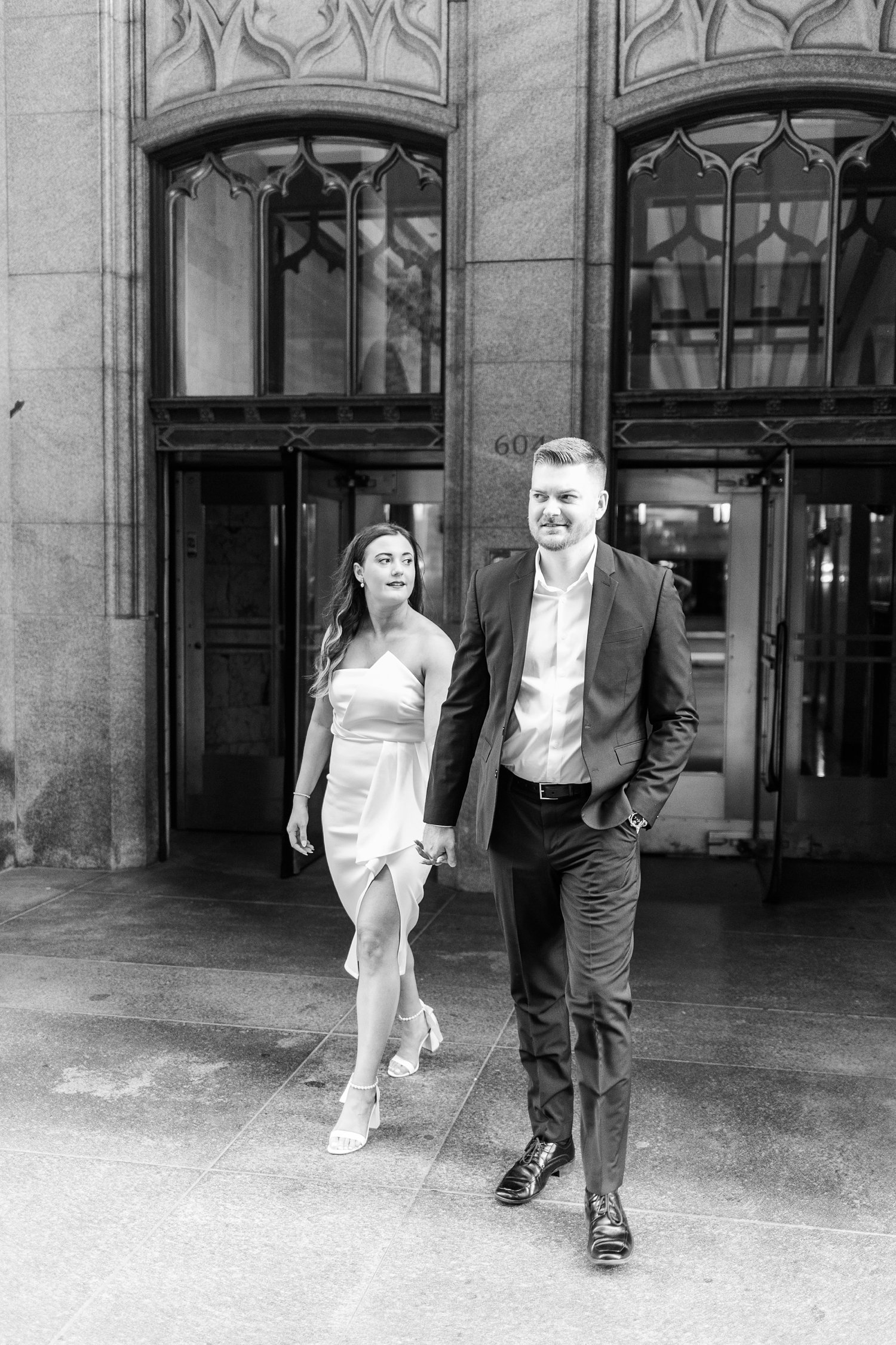 Jenna and Dustin walk hand in hand as they leave The Equitable Building in downtown Des Moines, IA | CB Studio