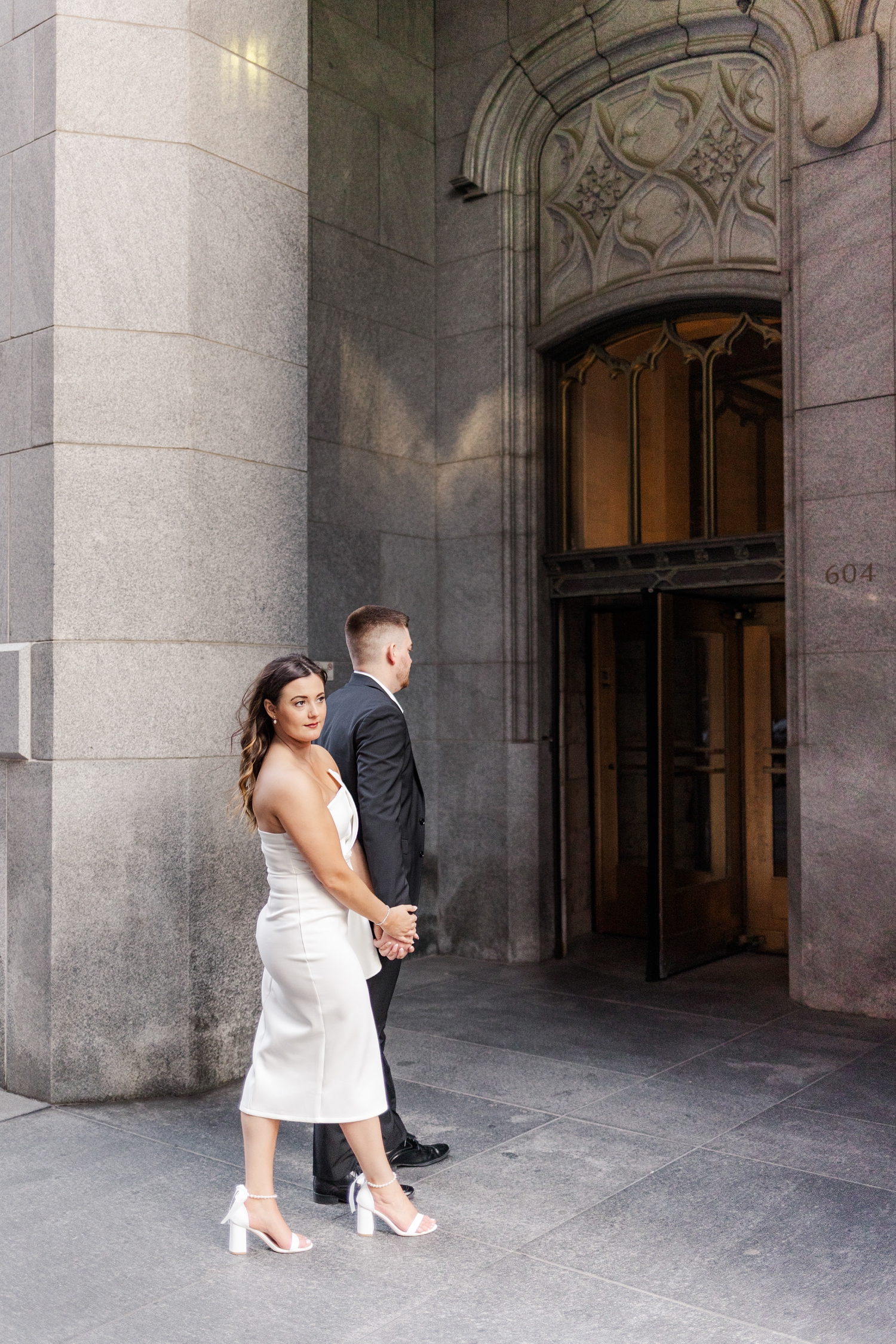 Jenna and Dustin walk hand in hand as they enter The Equitable Building in downtown Des Moines, IA | CB Studio