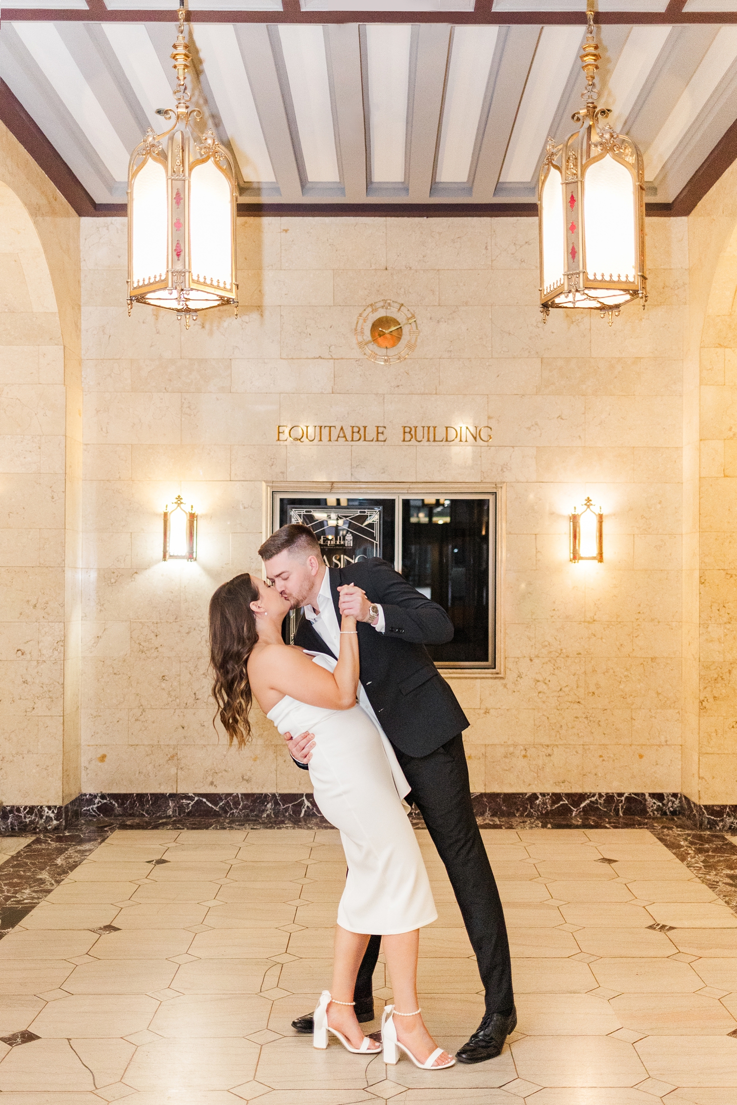 Dustin dips Jenna back for a kiss in the lobby entrance of The Equitable Building in Des Moines, IA | CB Studio