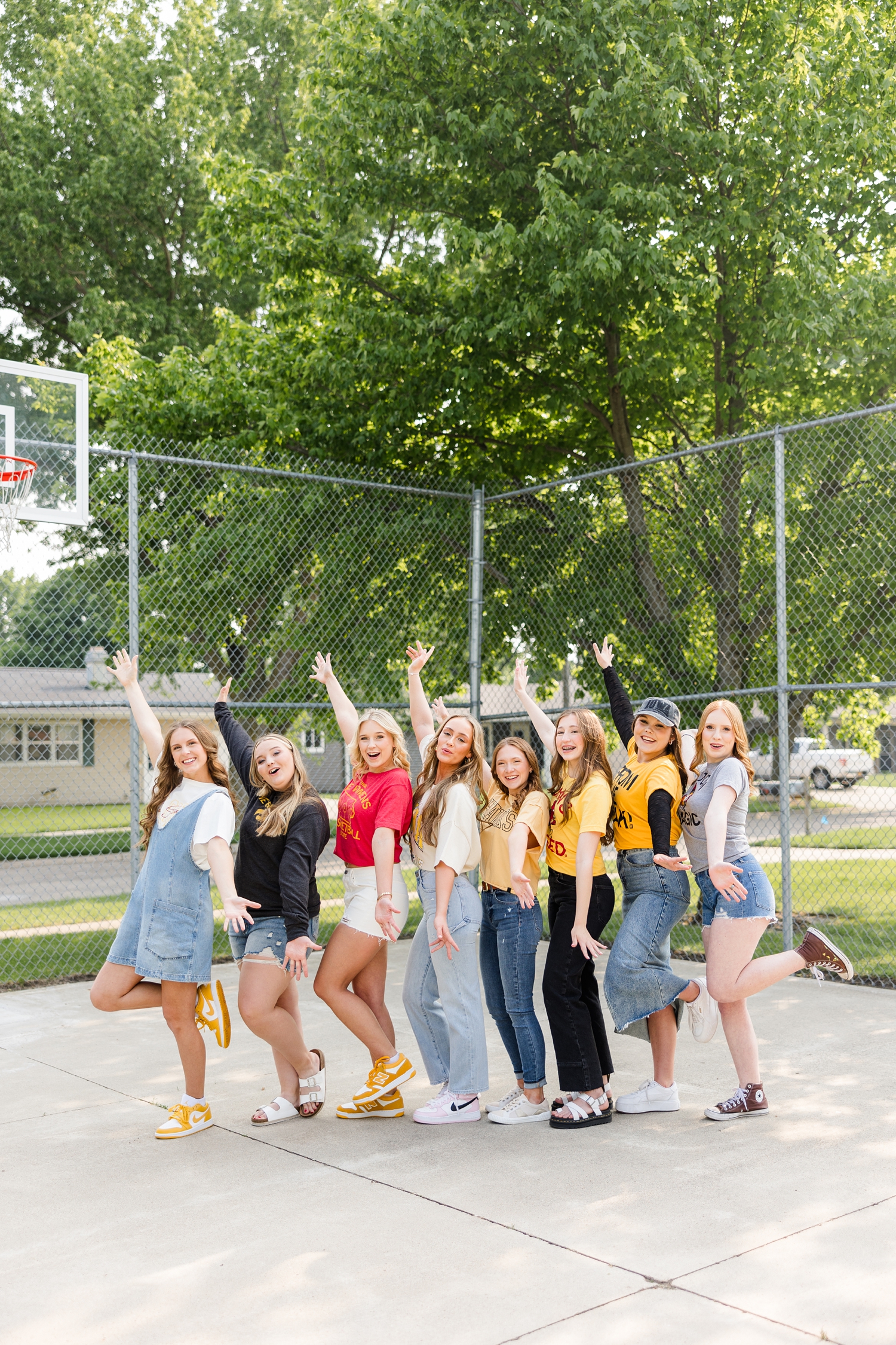TEAM 25, all wearing Iowa or Iowa State clothing, cheer with their hands in the air in an outdoor basketball court | CB Studio