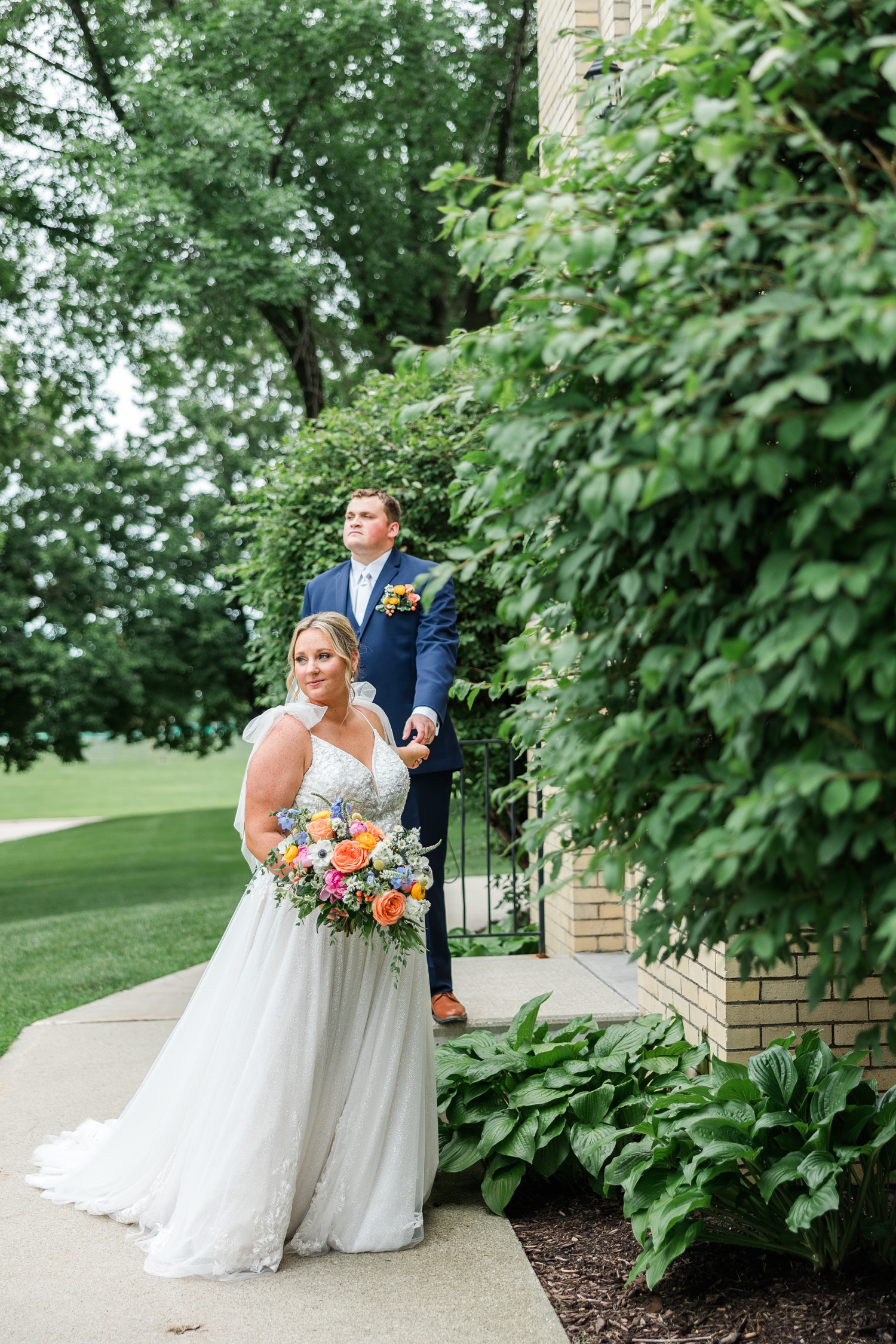 Shelby leads Taylor down stairs as they walk away from St. John the Baptist Catholic Church in Bancroft, IA | CB Studio